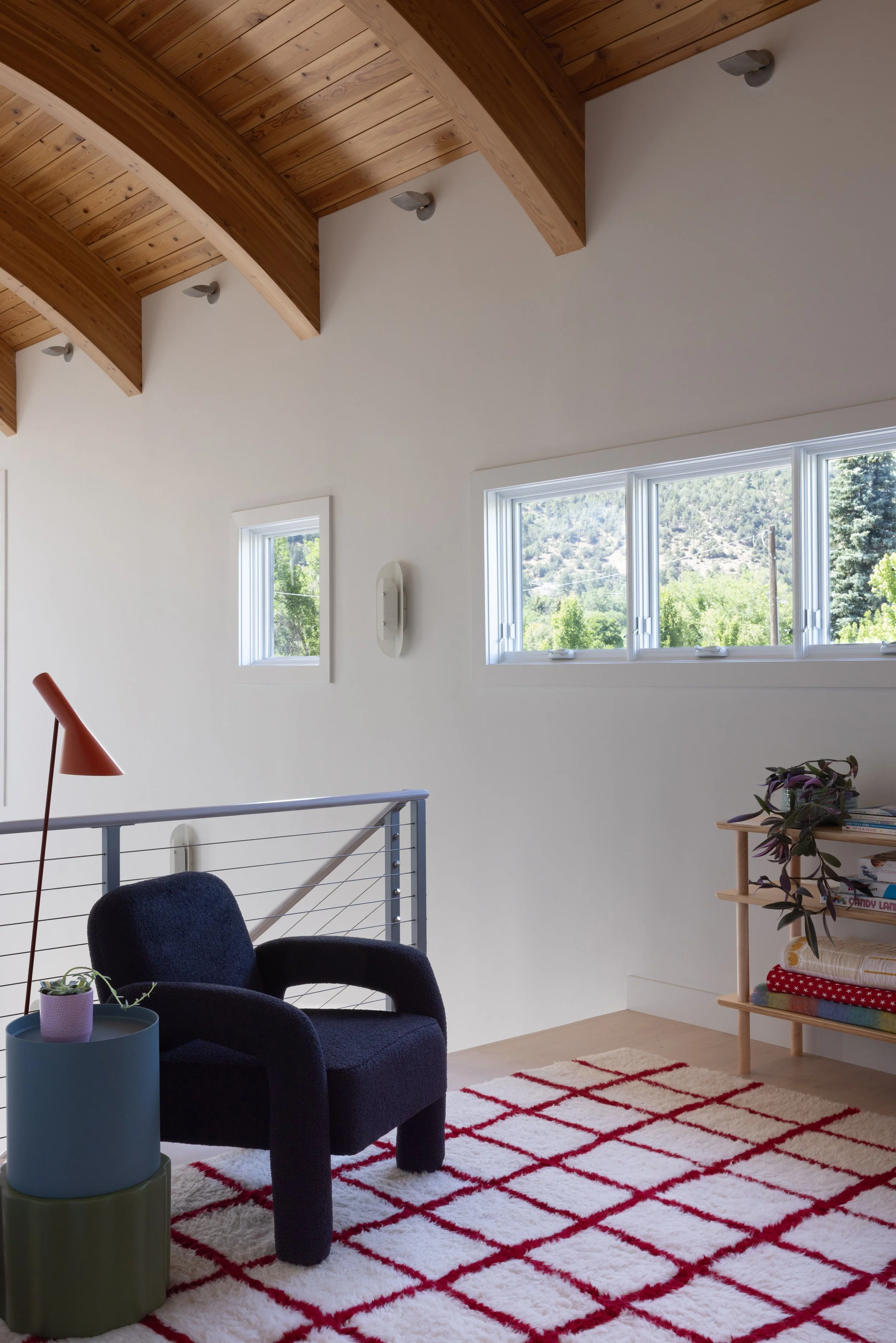 Landing with exposed beams and a geometric rug.