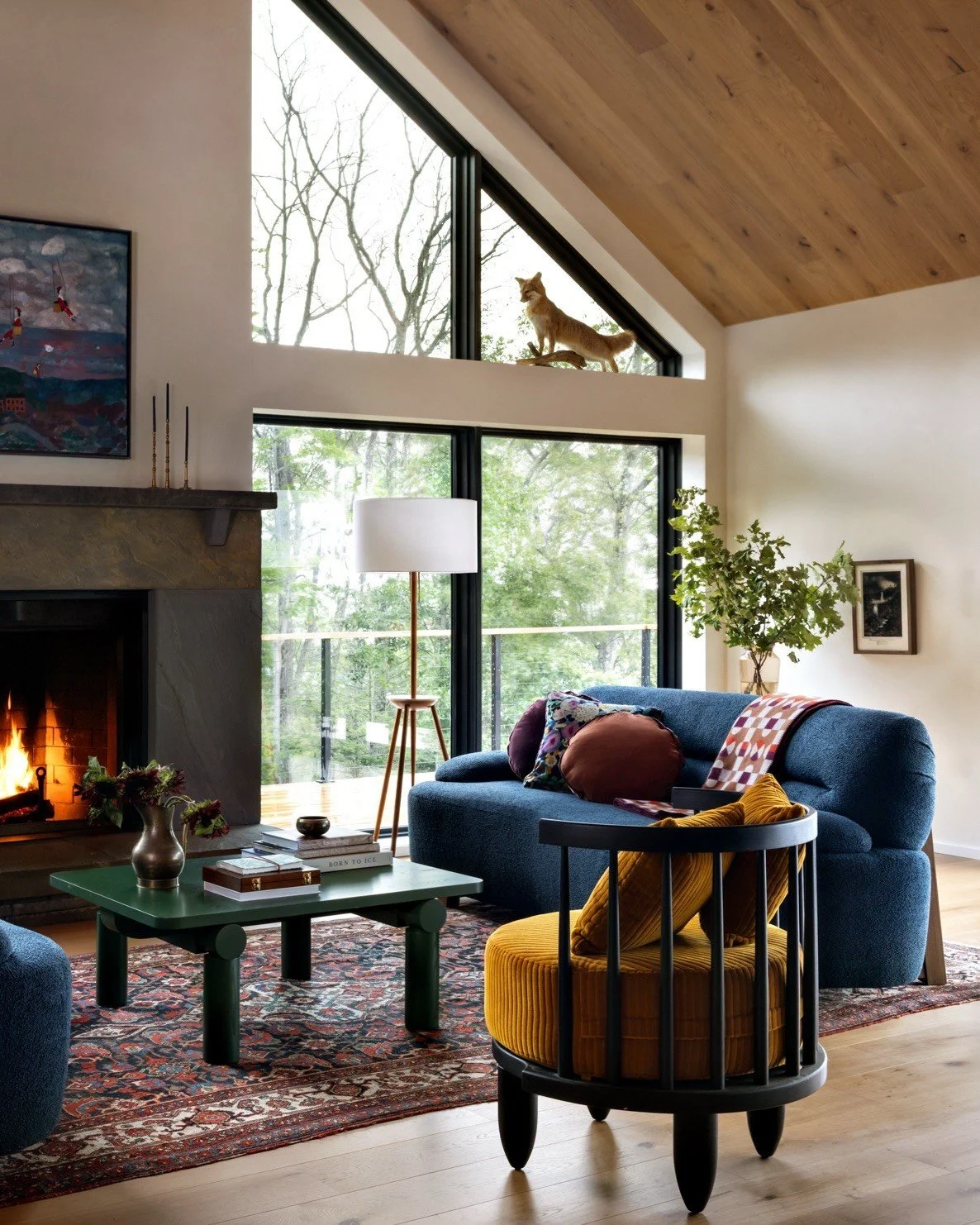 Blue sofa and mustard chair beside a mountain-home fireplace