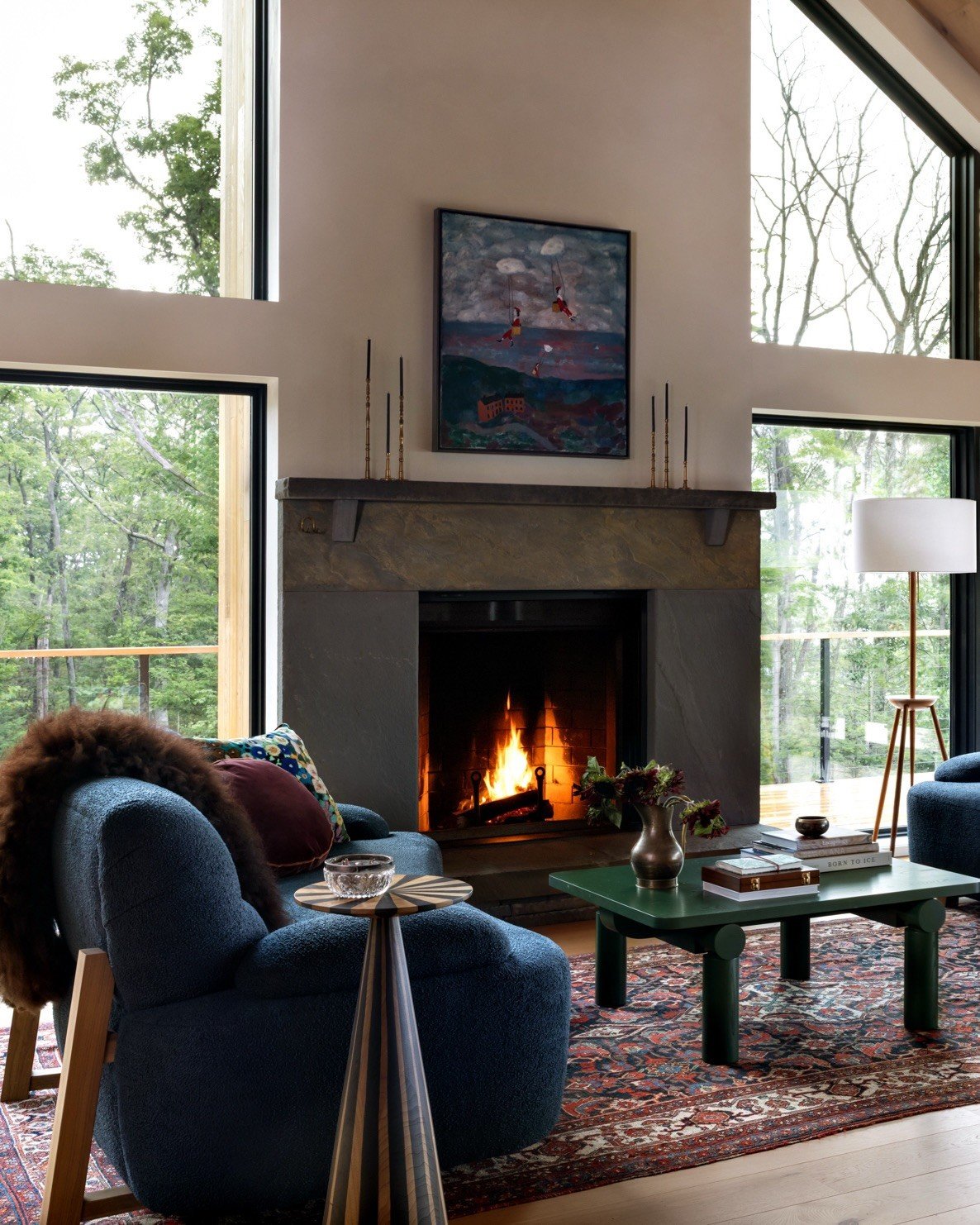 Blue sofa and black fireplace framed by tall windows
