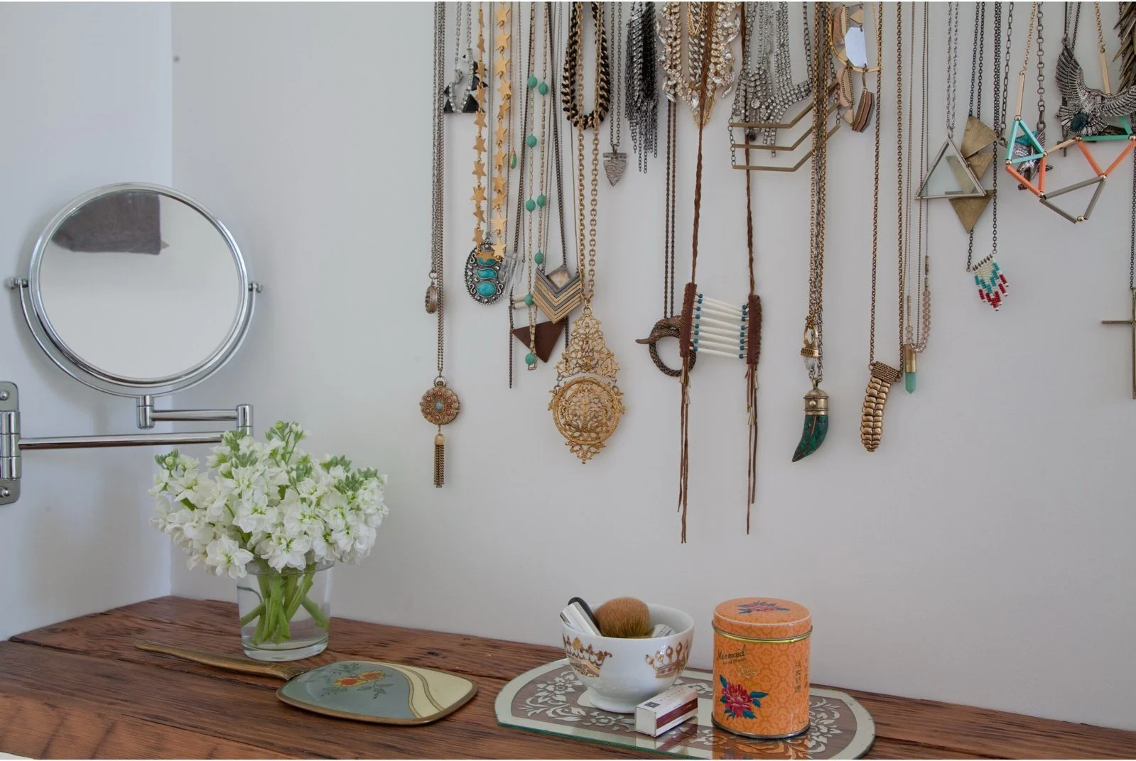 Wood dressing table with necklaces arranged on the wall