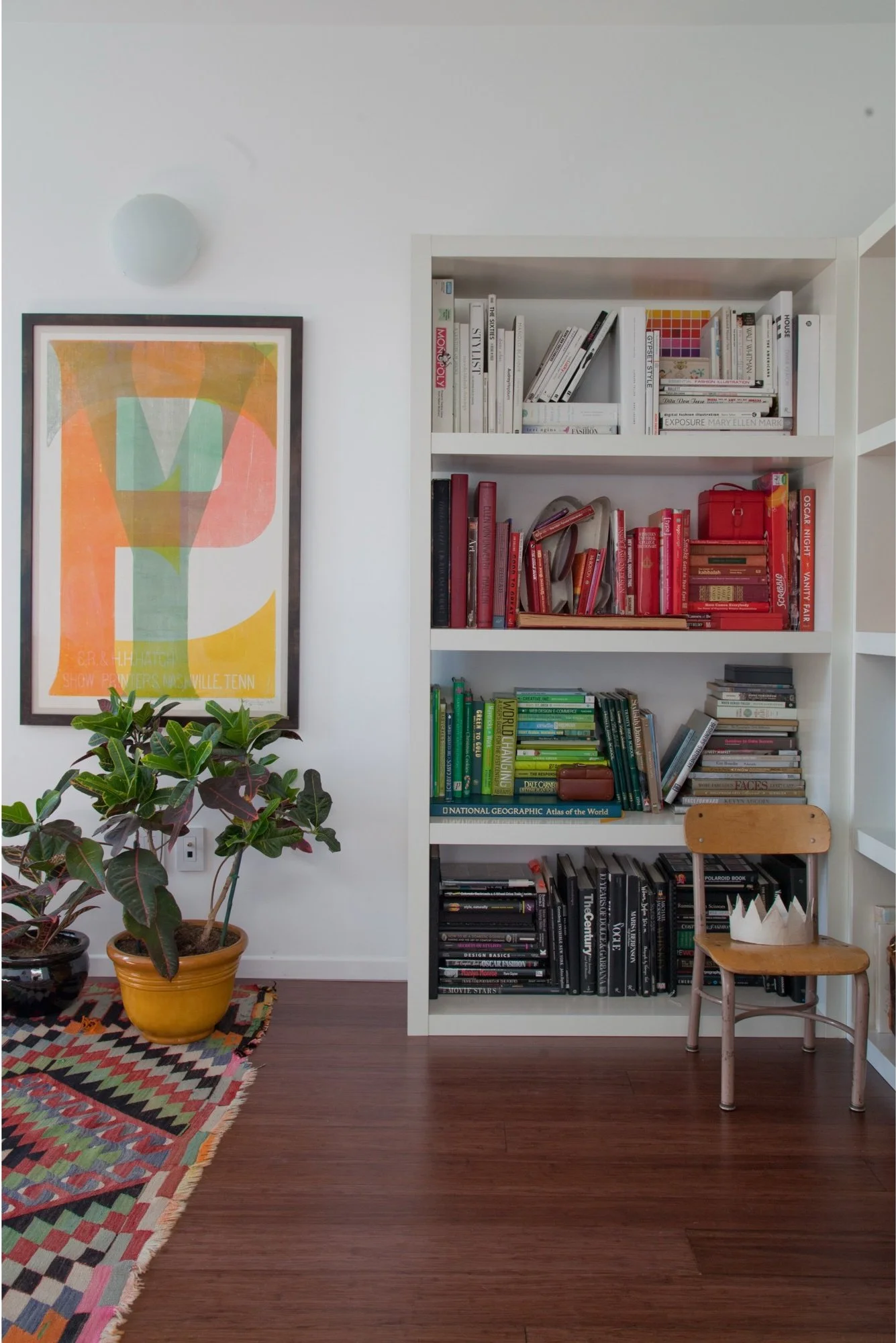 White bookcase styled with books, pottery and framed art