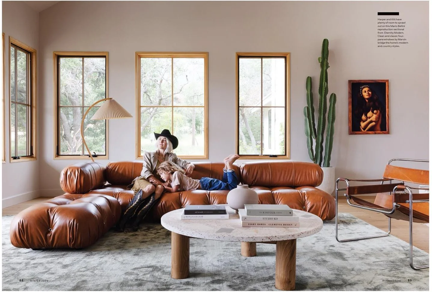 Magazine photograph of a living room with caramel leather seating and a round table