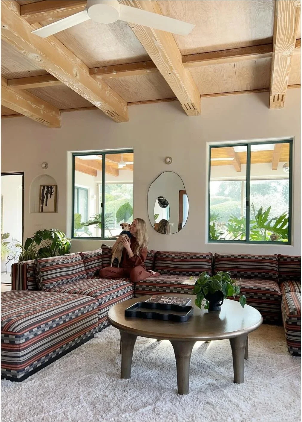Styled living room with a seated designer patterned sofa and pale textured rug