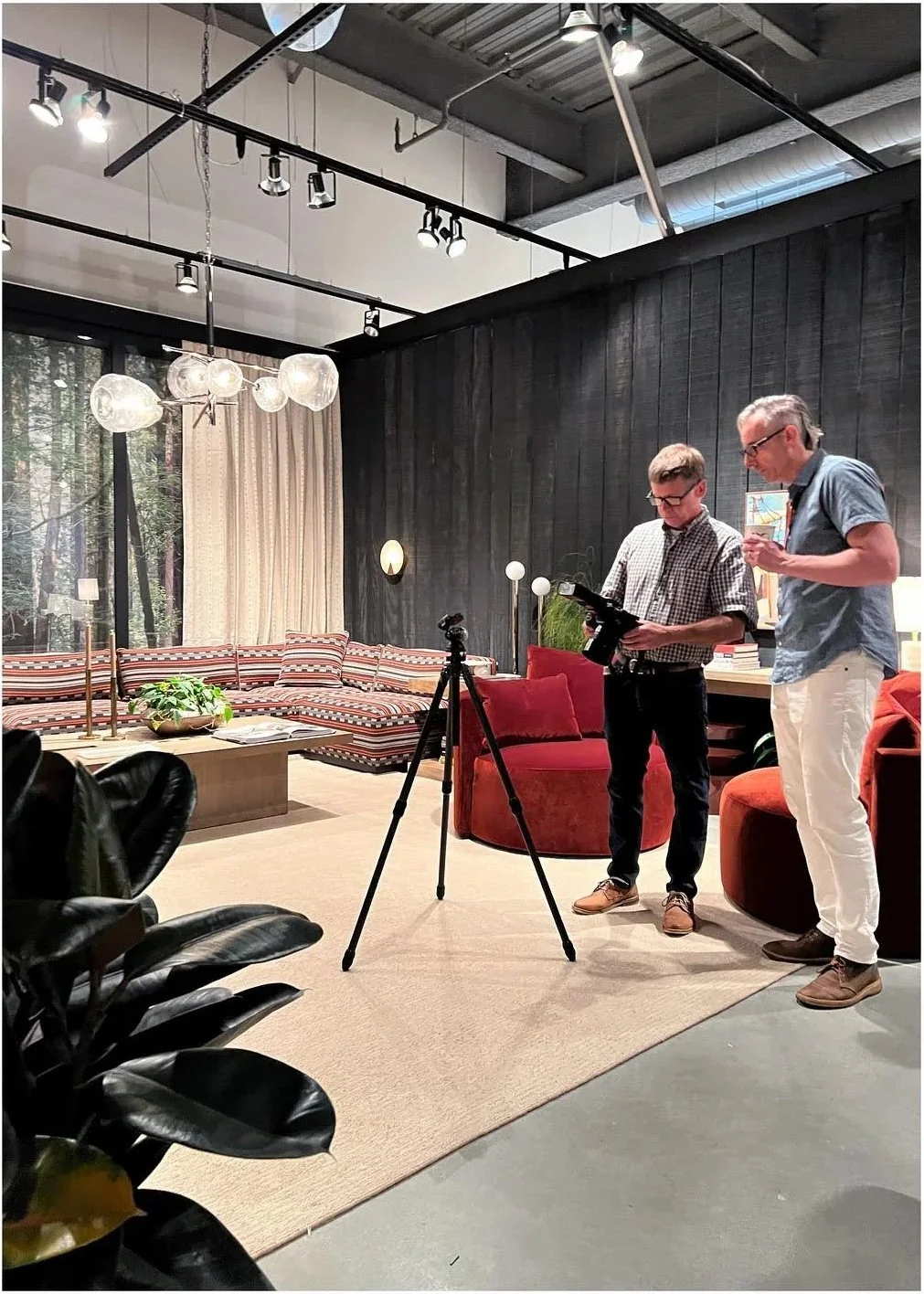 Designers presenting the showroom with filming equipment in the foreground