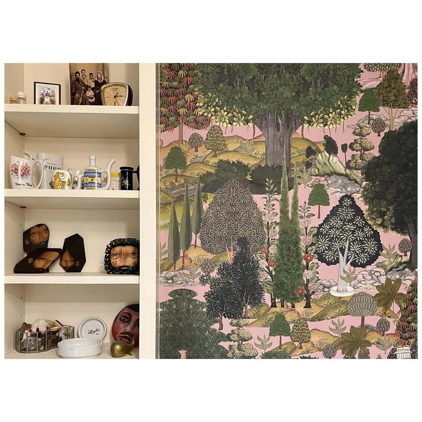 White display shelves beside richly patterned landscape wallpaper