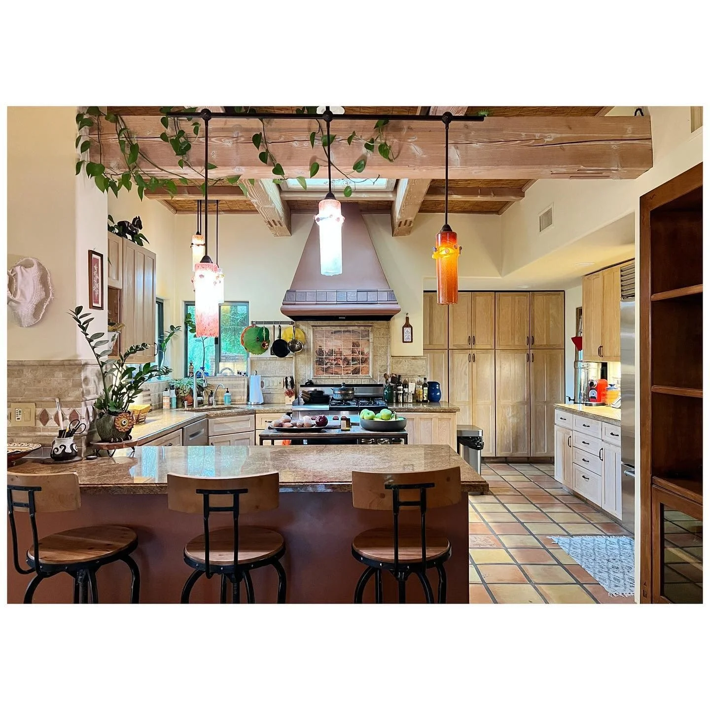 Original kitchen with timber ceiling beams island seating and varied cabinet finishes