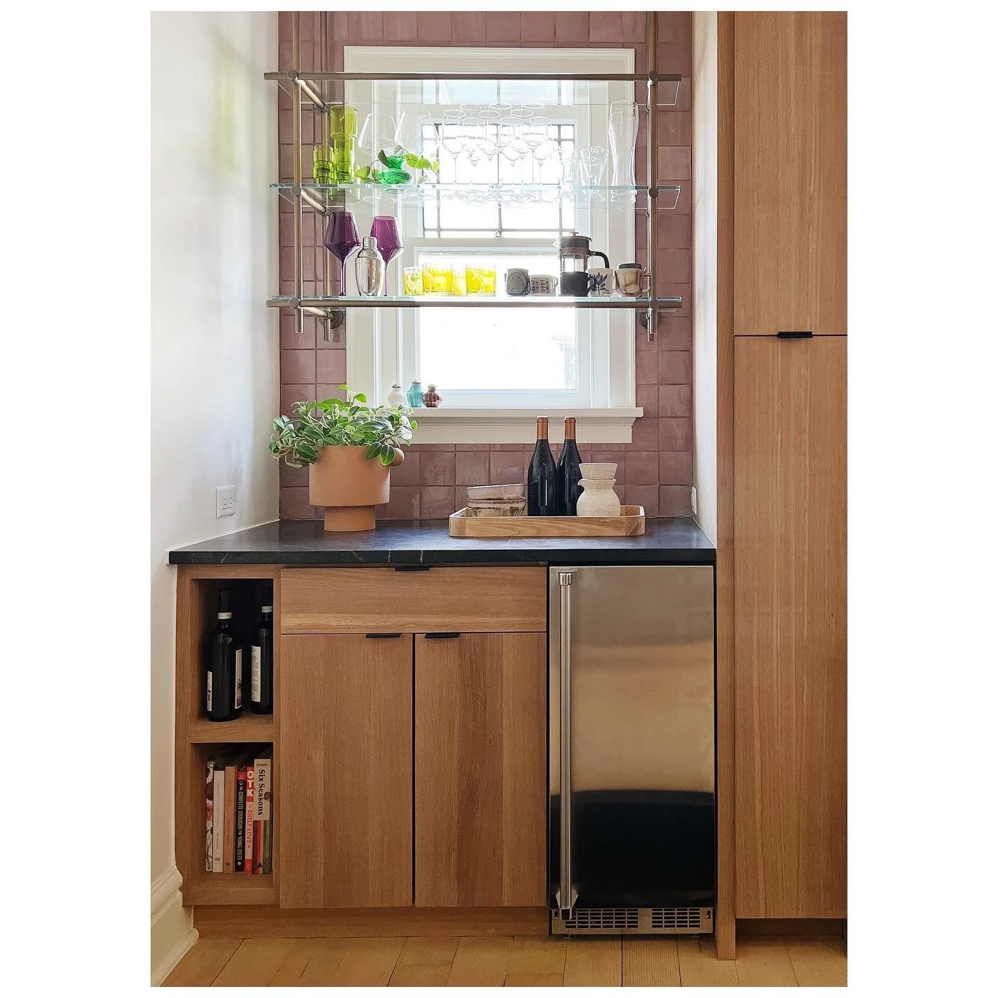 Original kitchen window above wood cabinets and a small countertop appliance