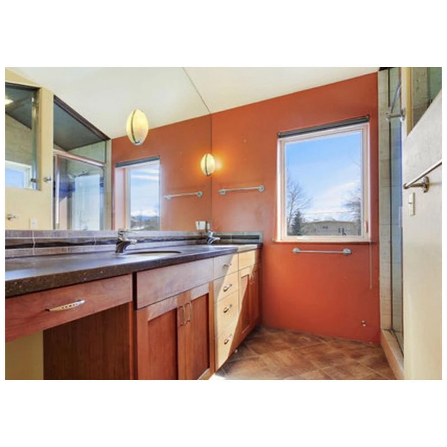 Bathroom before renovation with timber cabinetry, a long mirror and warm orange walls