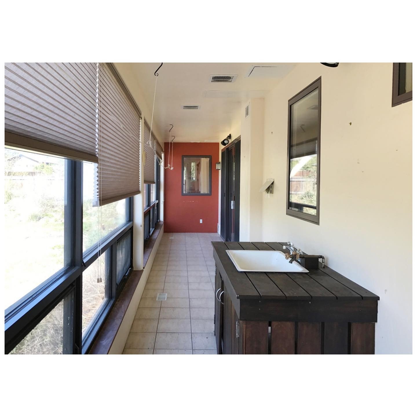 Sunroom before renovation with an older tiled floor, pale walls and a table tennis table