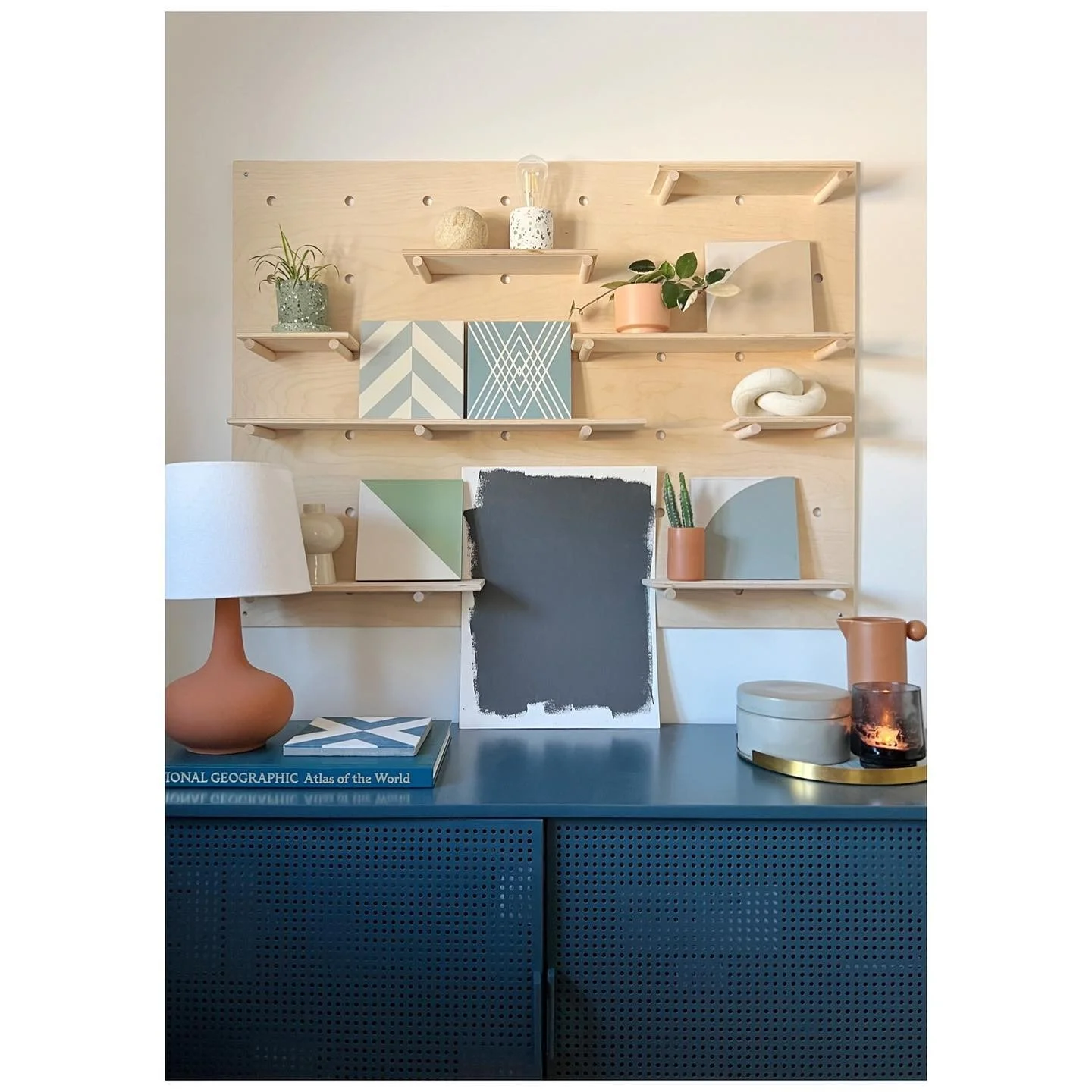 Bathroom concept samples, paint swatches and geometric tile references arranged above a blue sideboard