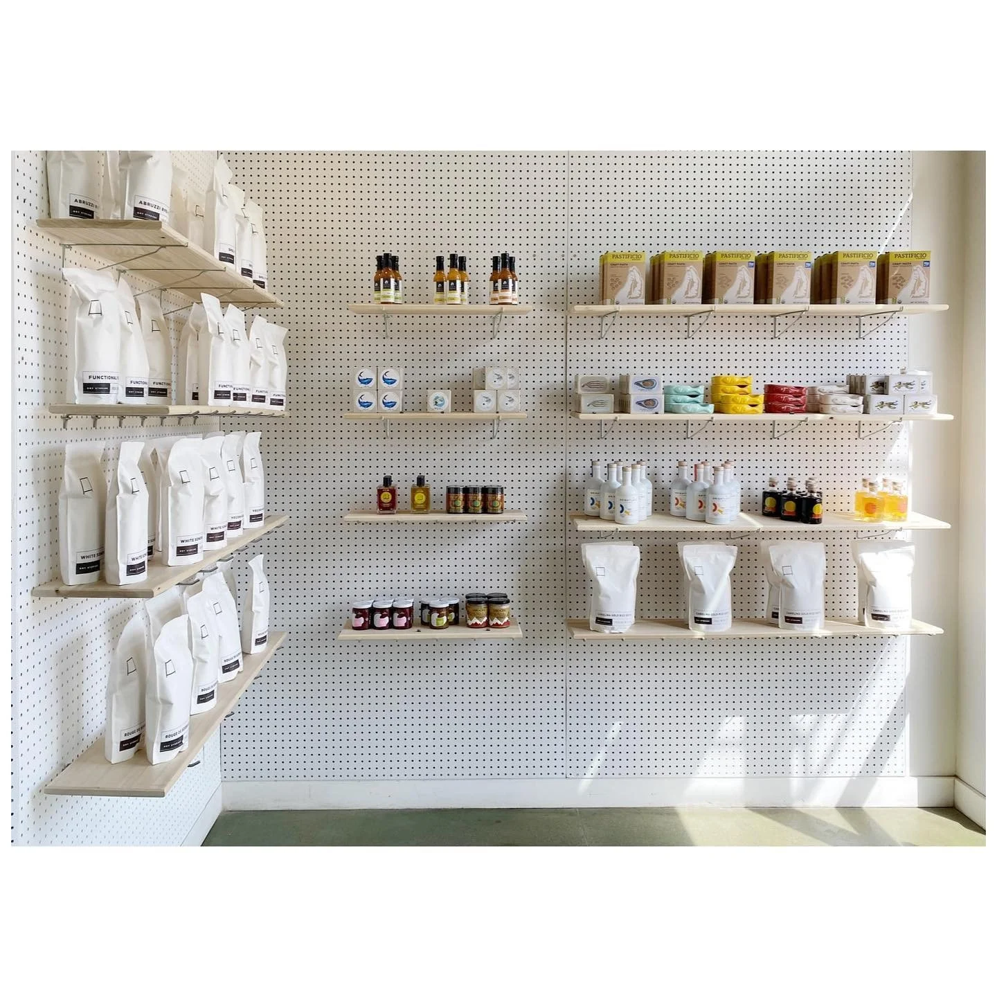 Bright retail shelves with packaged pantry goods and white product bags
