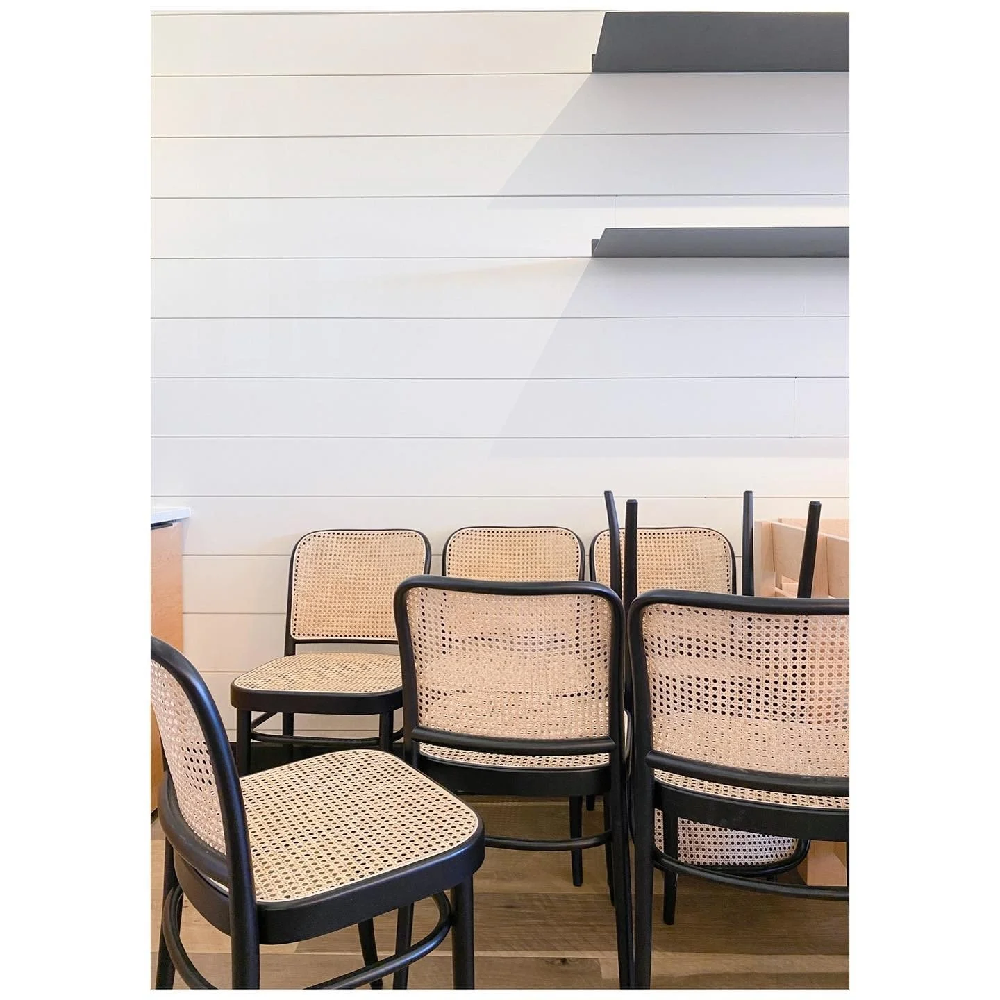 Group of black bentwood chairs with cane seats and backs ready for a project