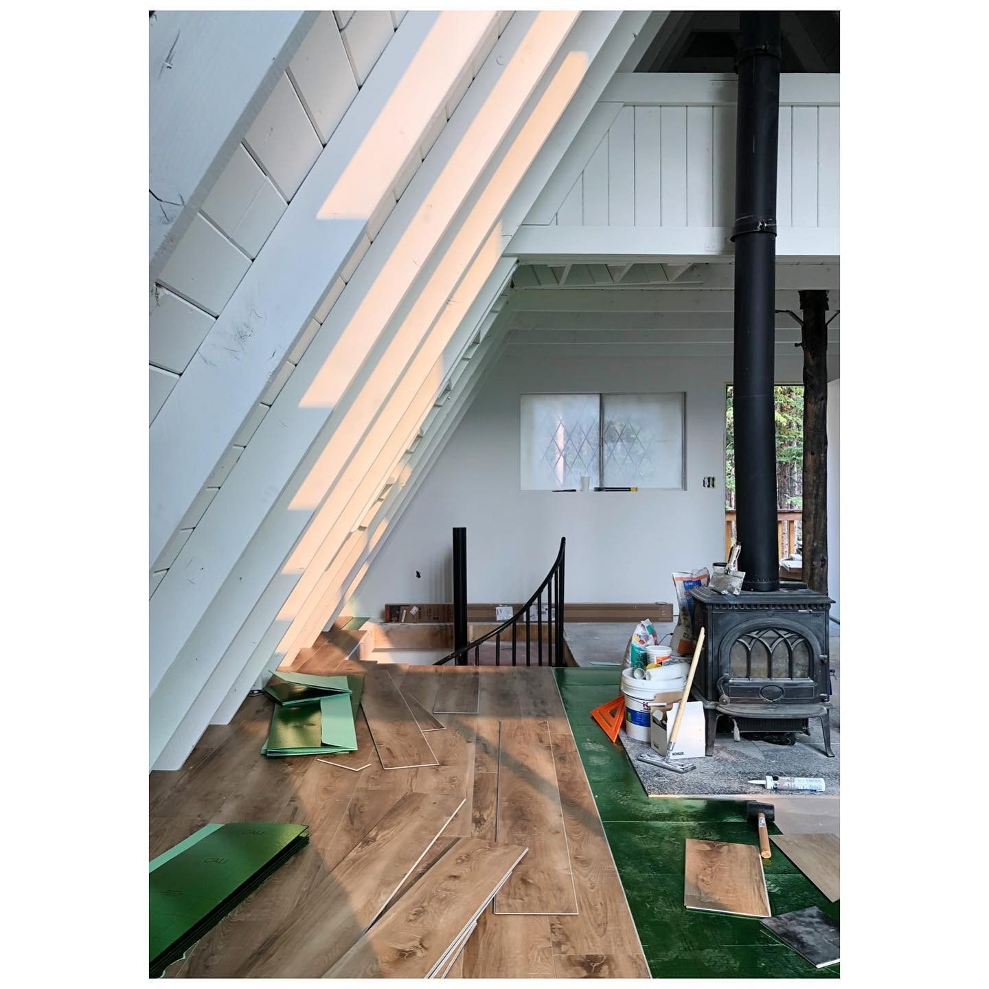 View toward a cabin stove and loft during timber floor installation