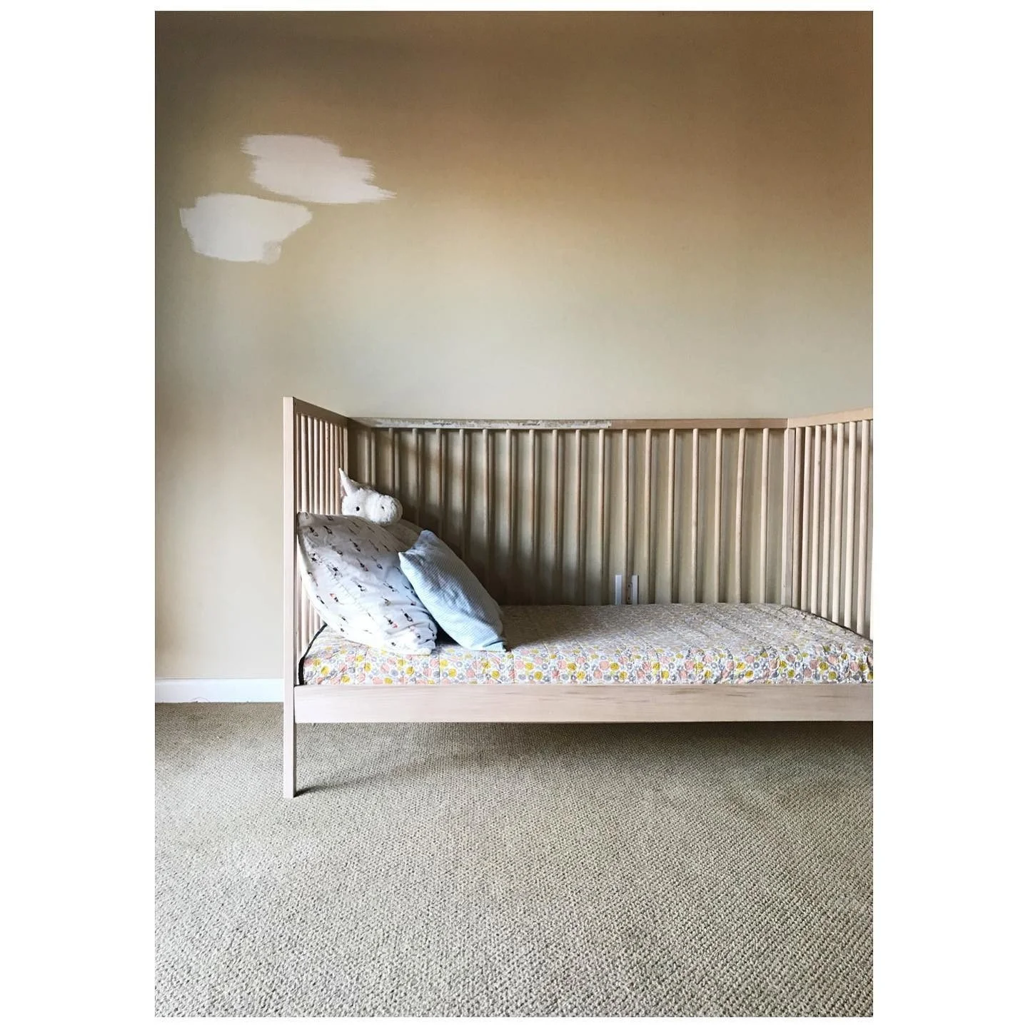 Bedroom before redesign with a pale timber daybed and unfinished wall paint