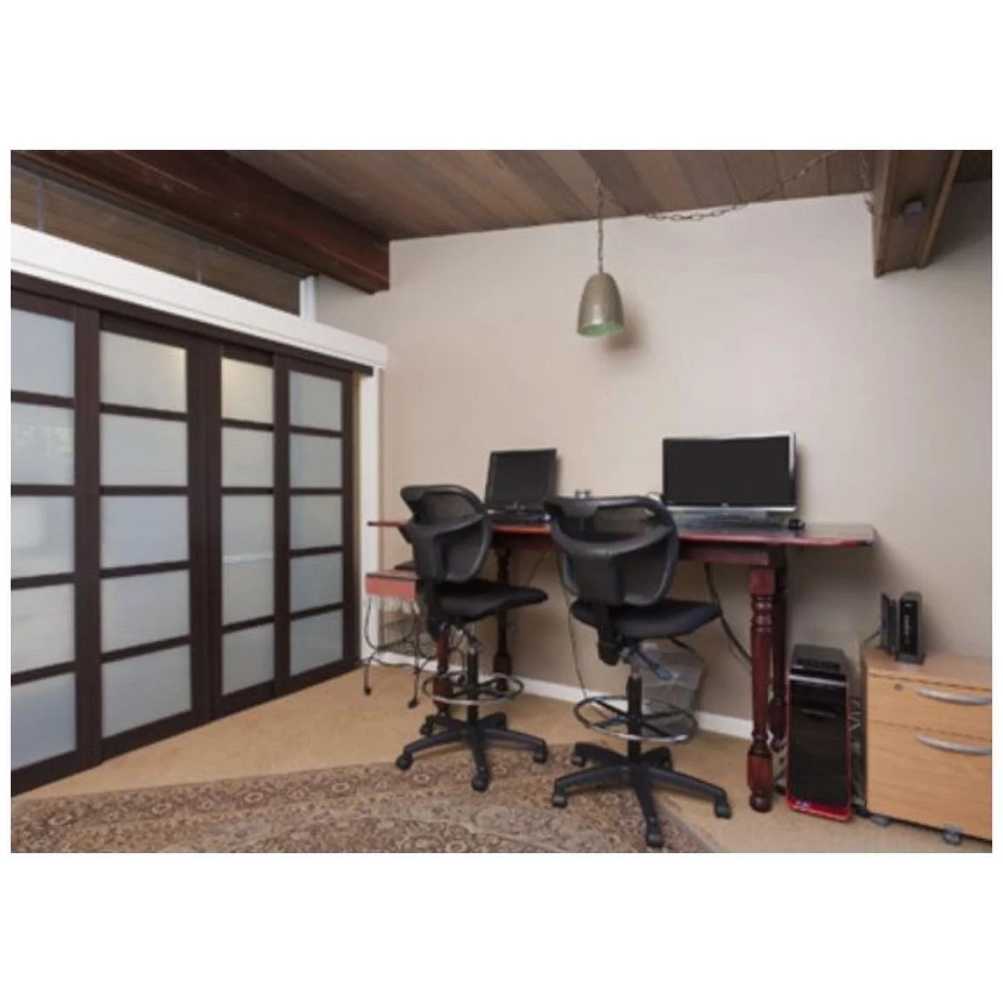 Room before redesign with two computer desks and a broad sliding partition