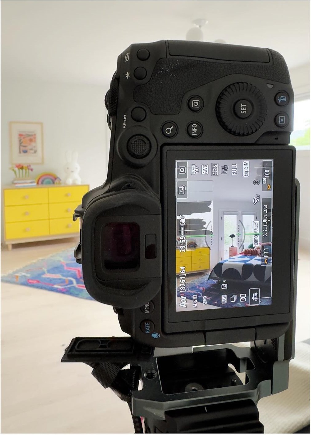 Camera on a tripod framing a colorful interior during a photo shoot