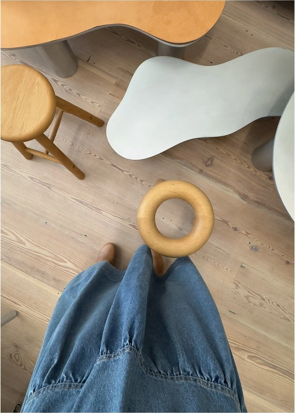 Curving pale coffee table and wood furniture viewed from above