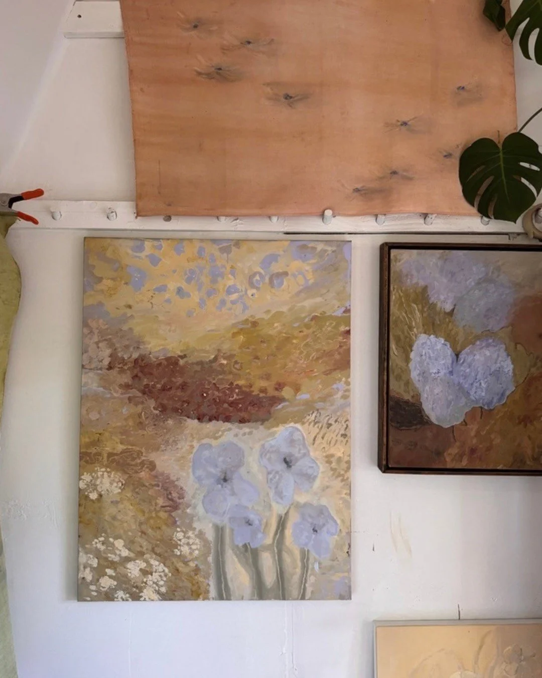 Framed paintings arranged beneath a natural wood ceiling