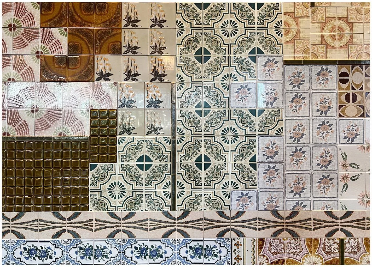 Patchwork of patterned glazed tiles in green blue cream and terracotta tones