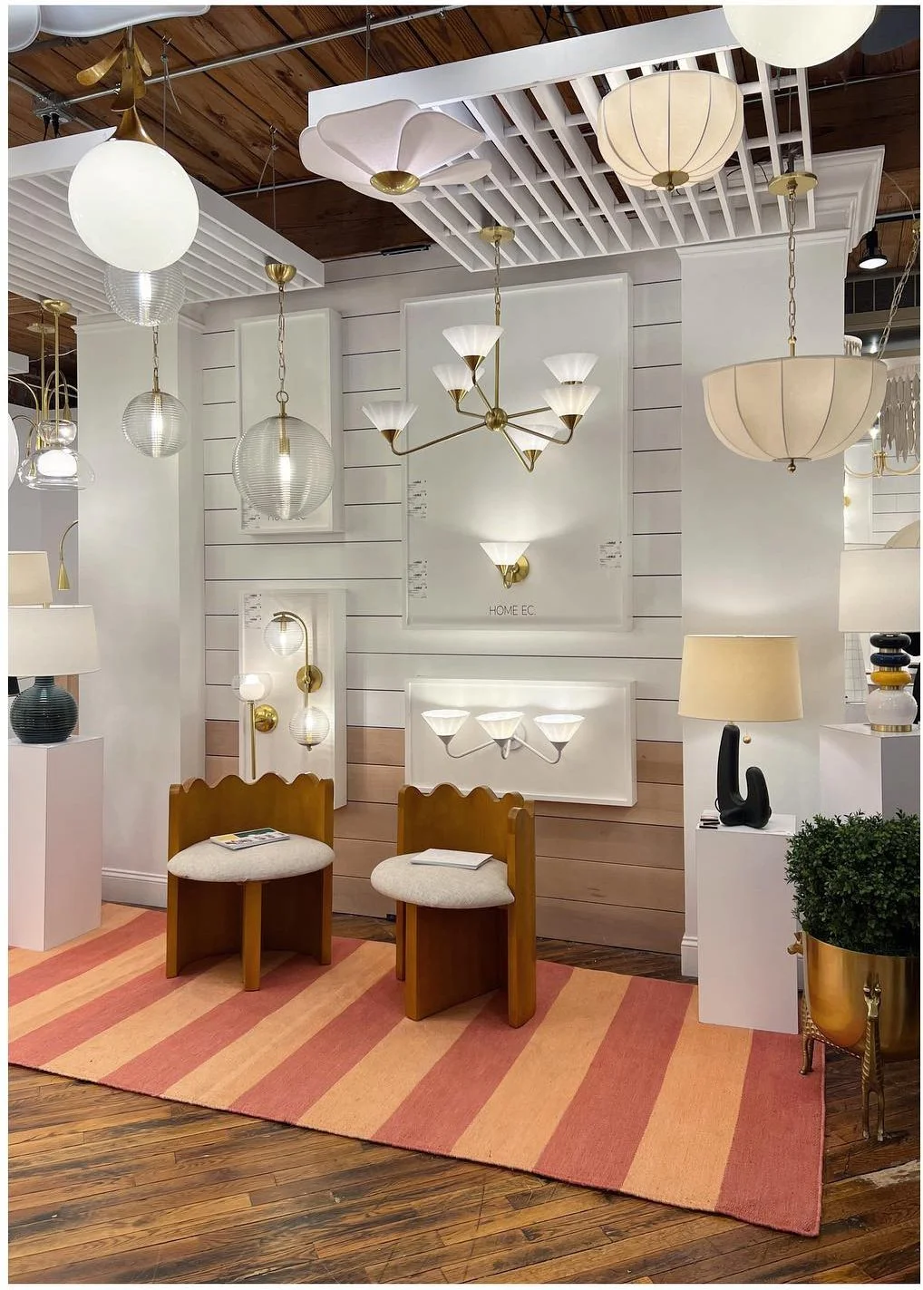 Lighting showroom with white globe pendants above striped display flooring