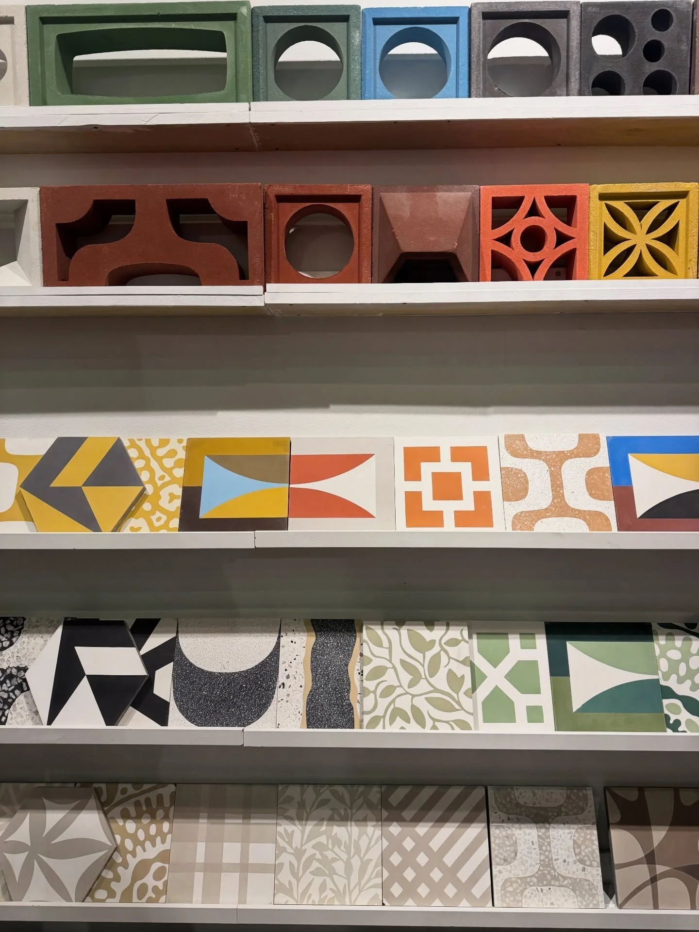 Shelves of colorful relief tiles and perforated masonry samples