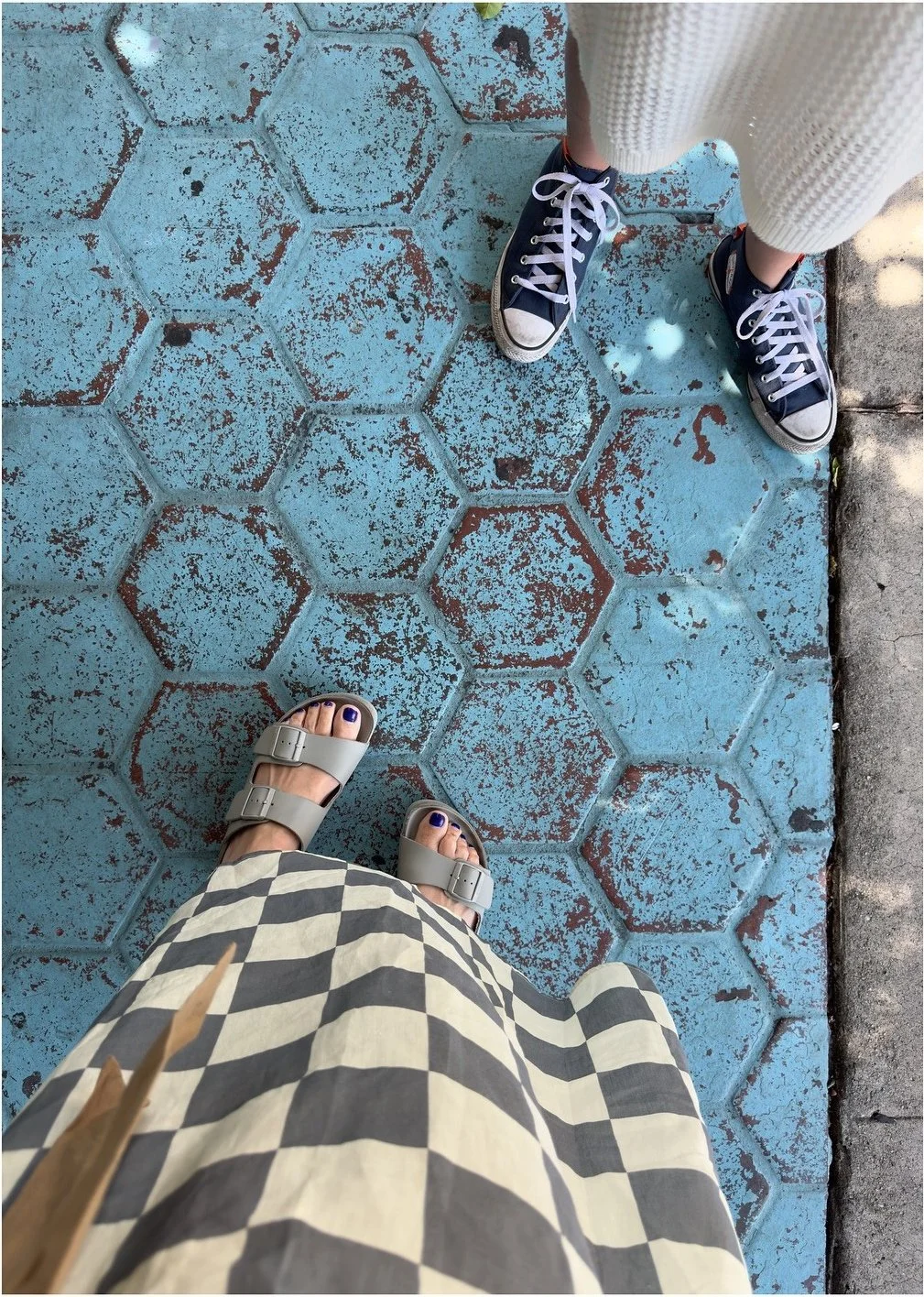 Weathered turquoise hexagonal floor tiles beside patterned clothing