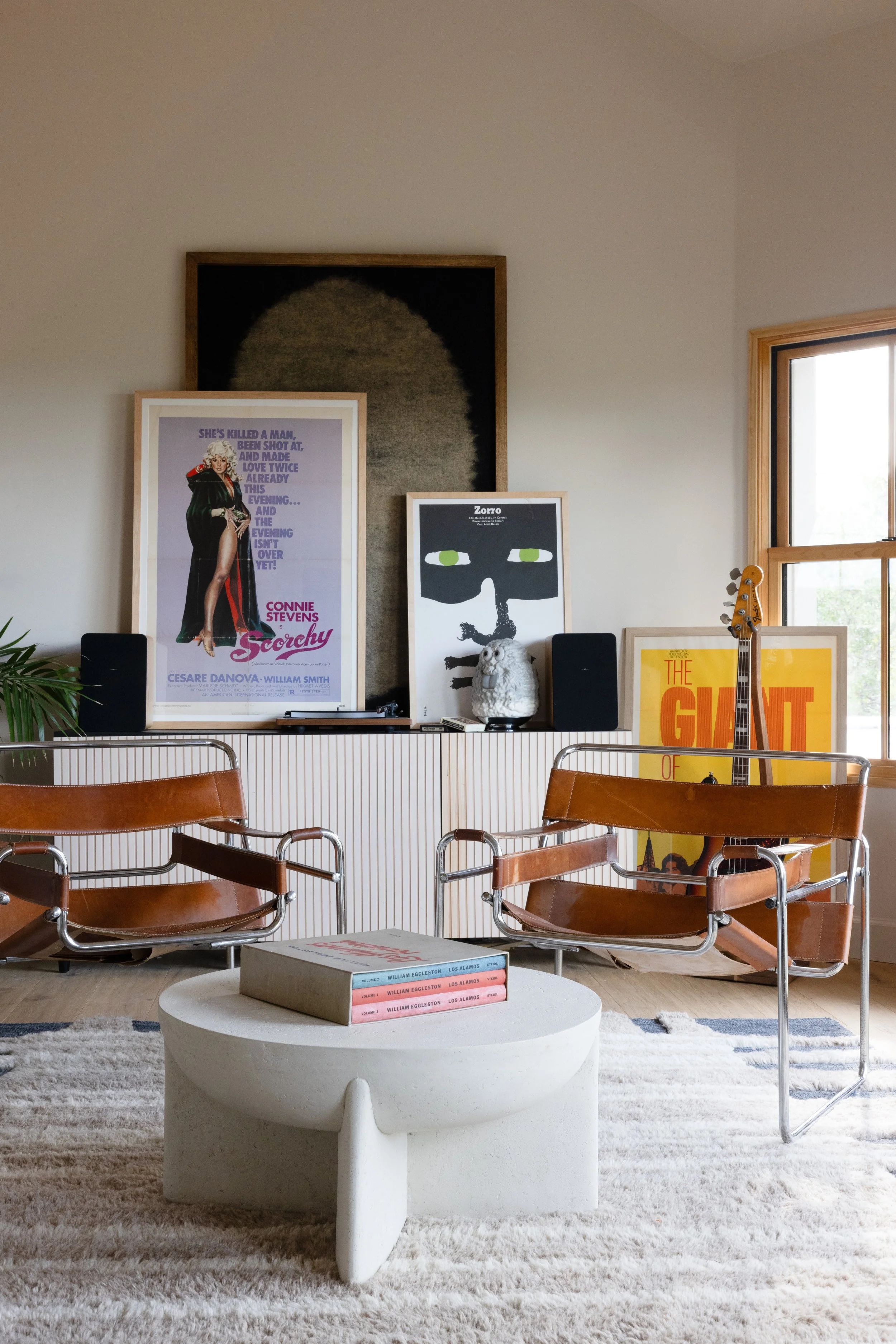 Living area with leather chairs, artwork, and a white coffee table.