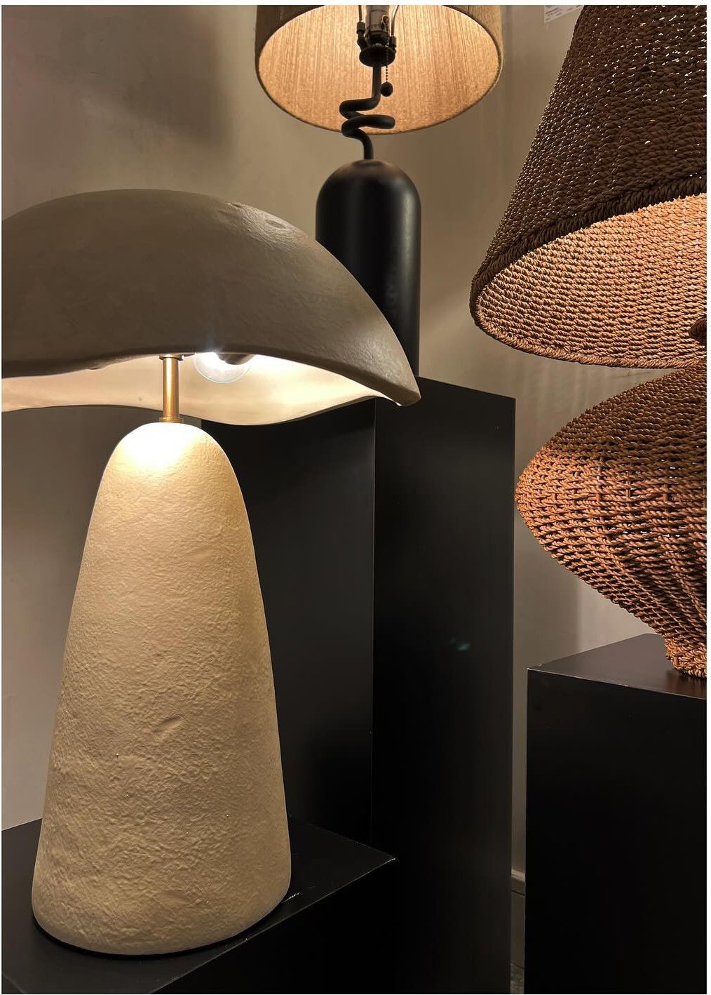 Sculptural table lamps in warm stone wood and woven finishes