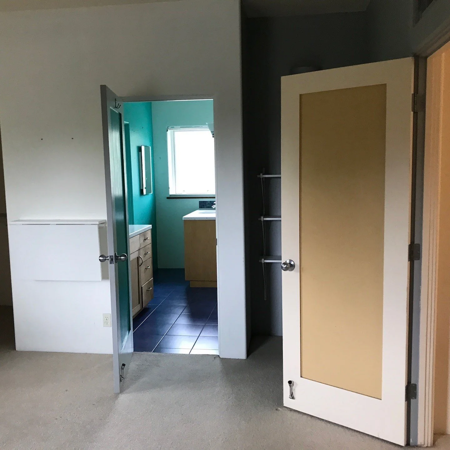 Original hallway with multicolored doors and carpeted floor