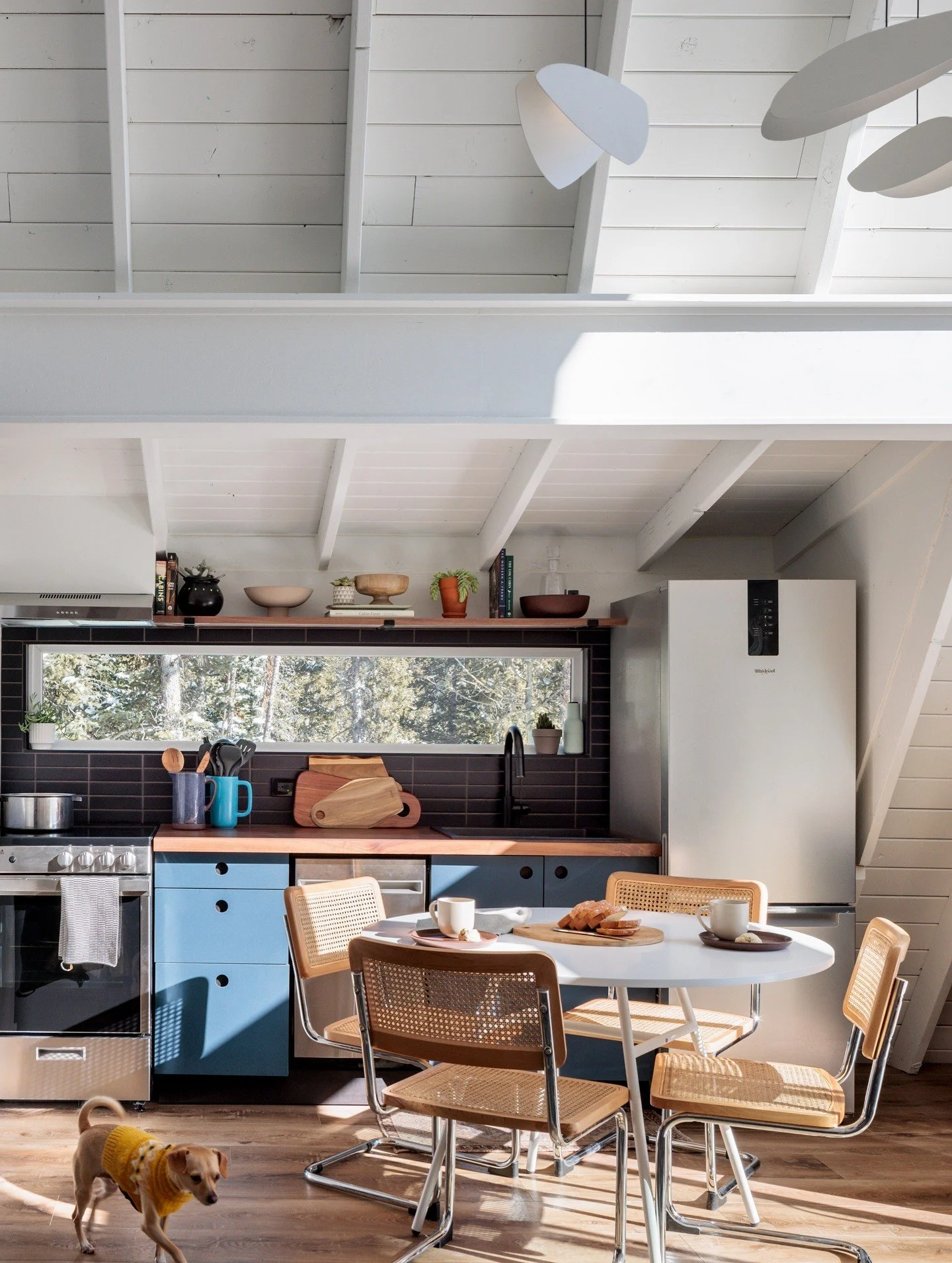 Renovated A-frame kitchen and dining room beneath white beams