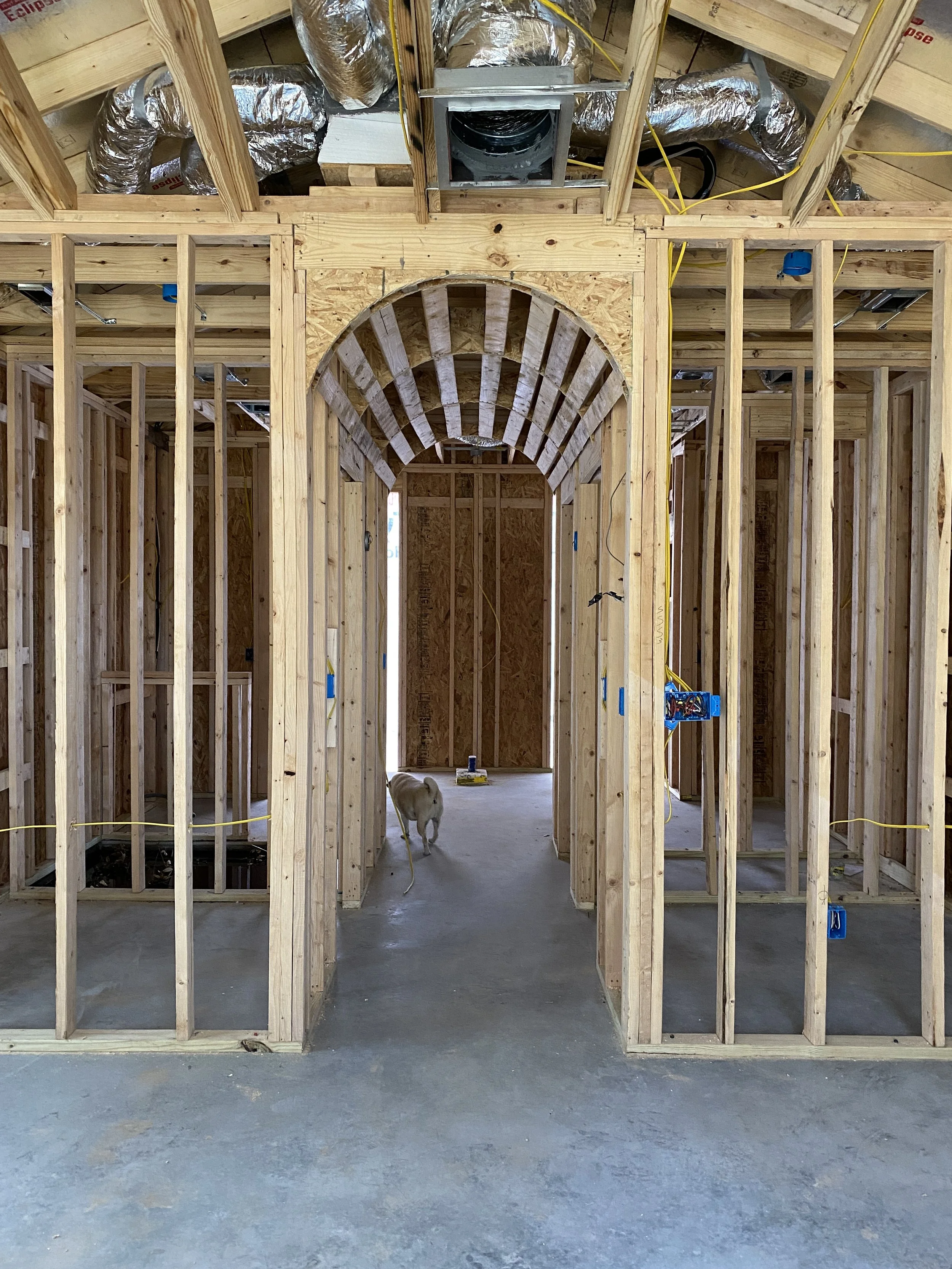 Timber framing forms an arched doorway in a home under construction.