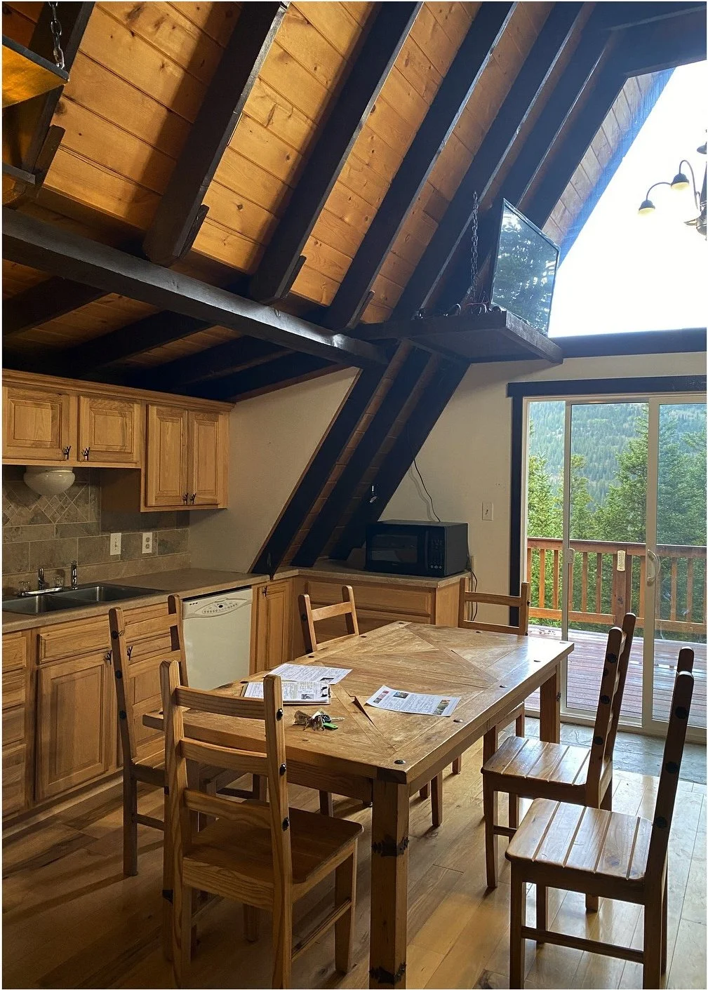 Original A-frame dining room with pine cabinetry and dark beams