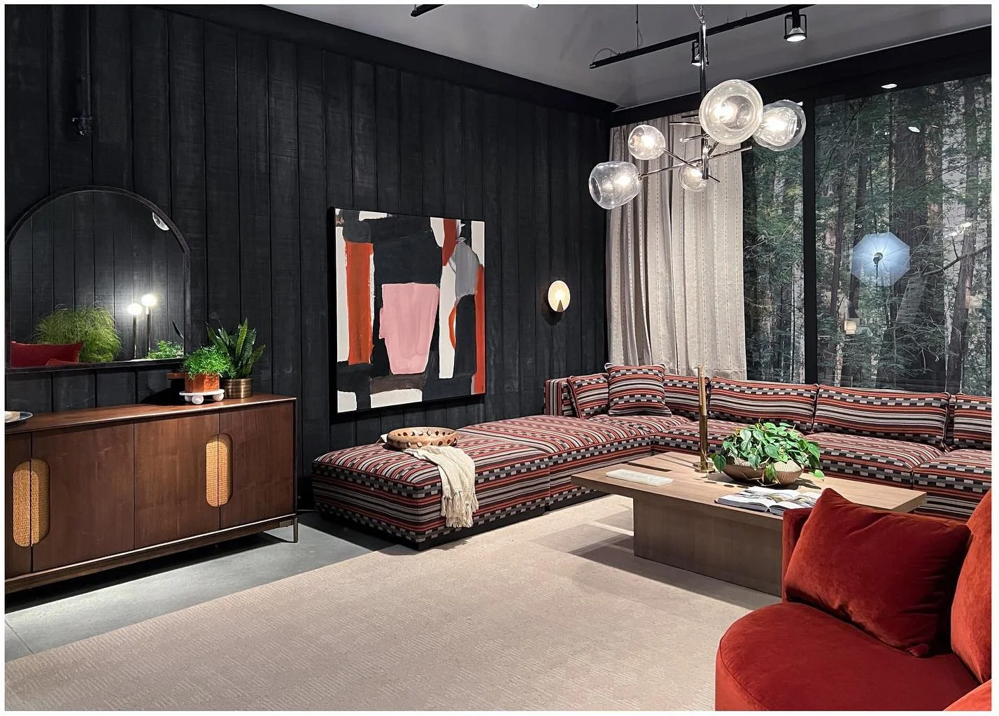 Moody showroom with dark walls long wood credenza and layered textiles