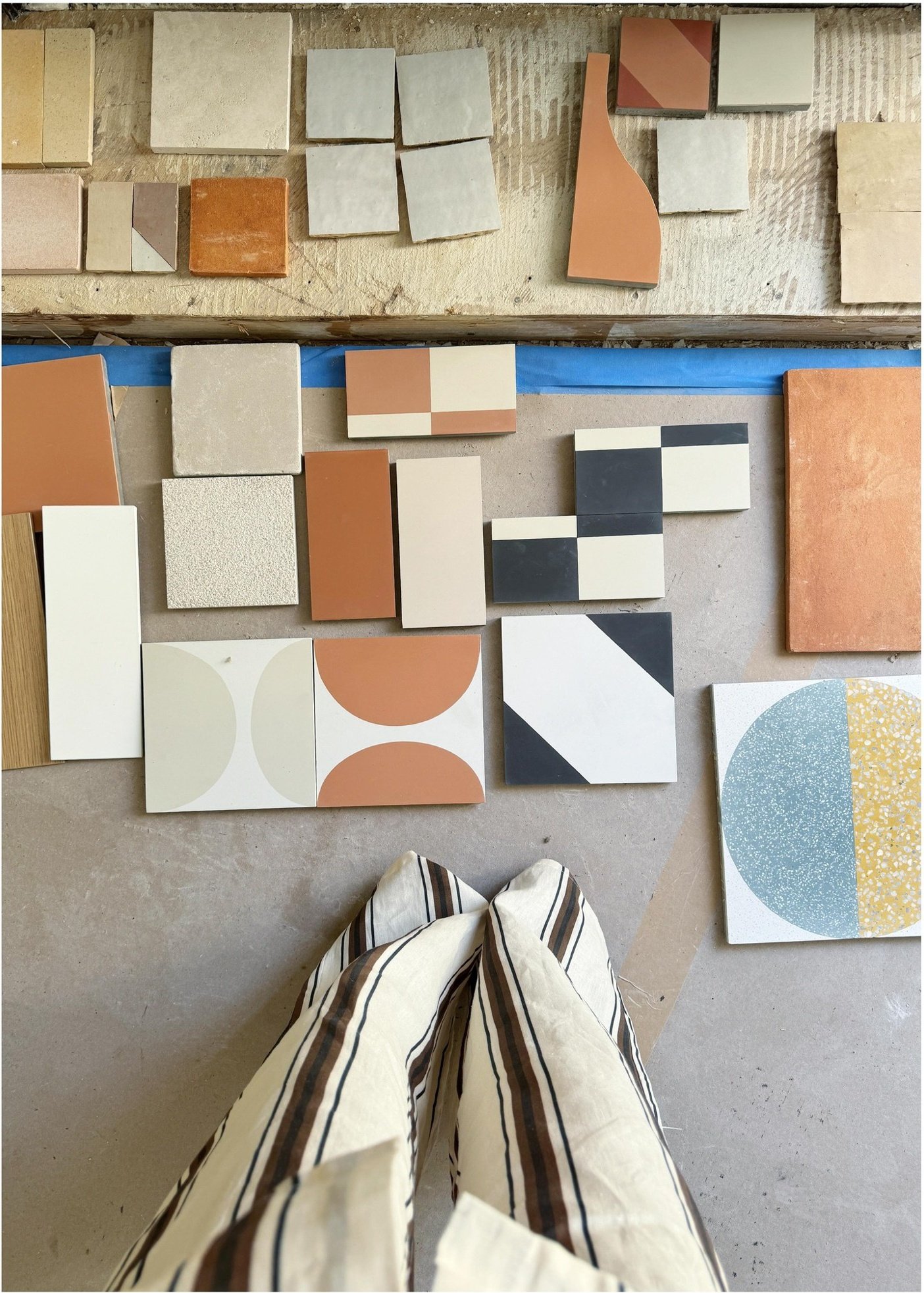 Tile and finish samples arranged in muted greens terracotta and geometric patterns