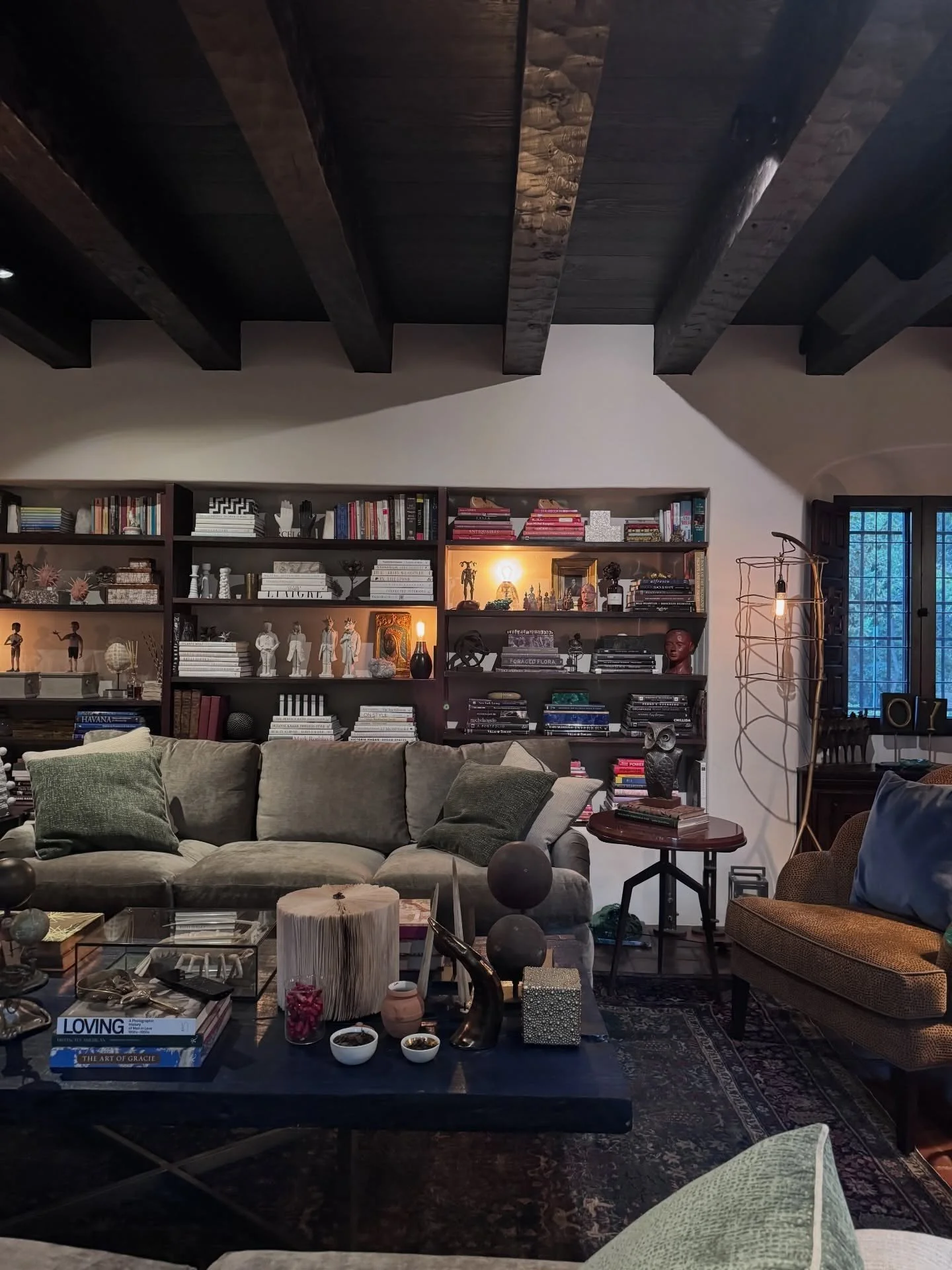 Layered living room with bookshelves and exposed wood beams