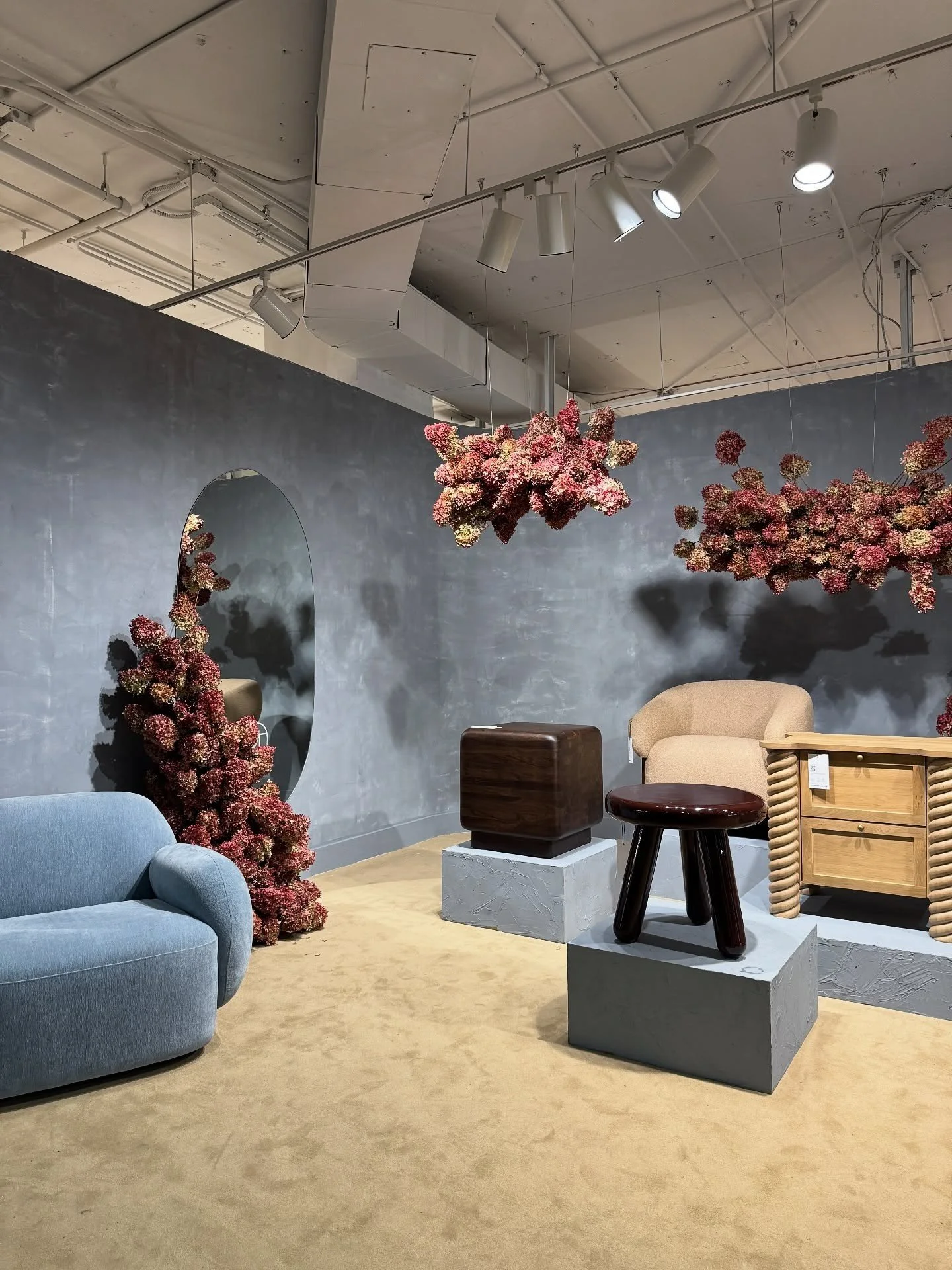 Furniture showroom with sculptural tables and floral installations