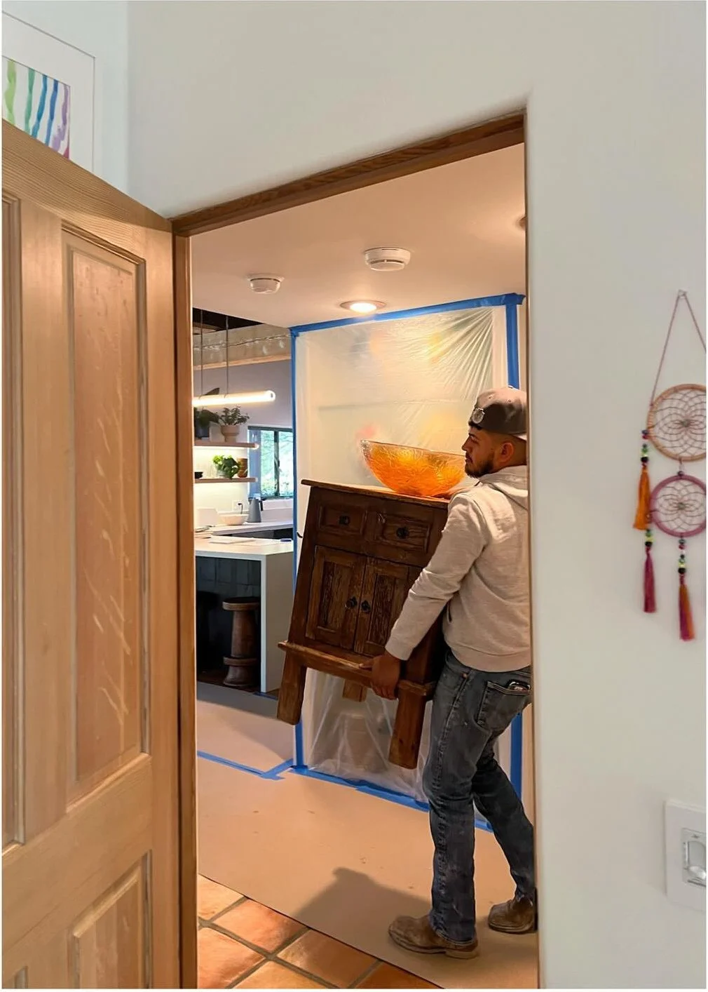 Worker carrying materials through a bathroom renovation doorway
