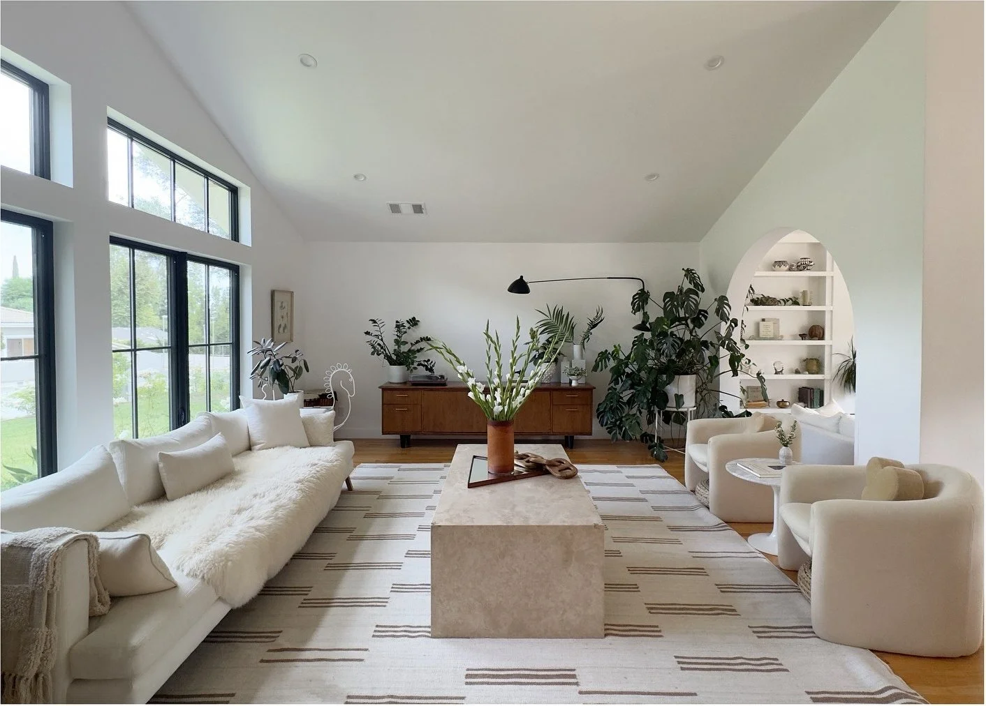 Bright vaulted living room with pale seating and large garden windows