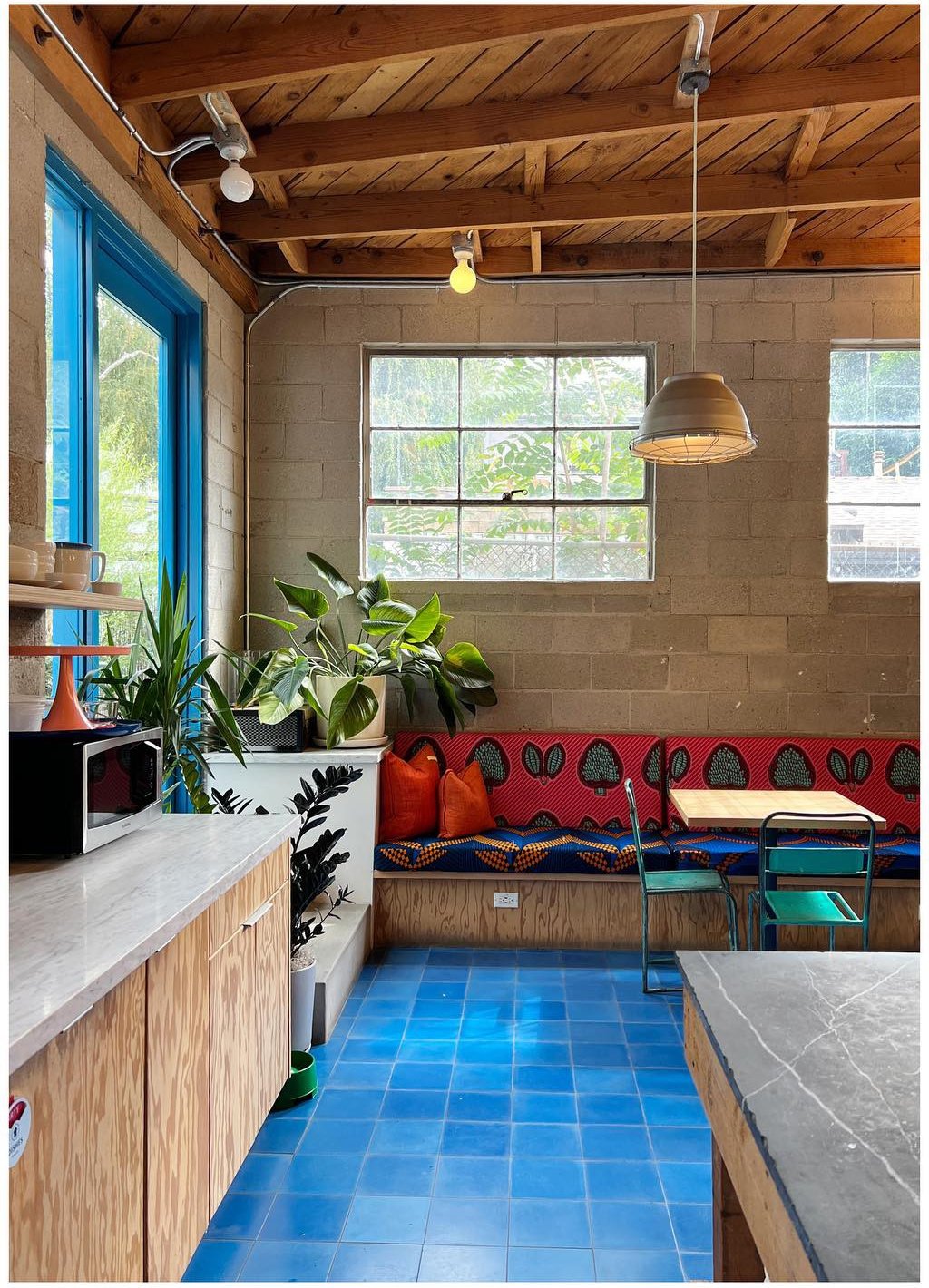 Studio kitchenette and patterned bench beneath exposed timber beams