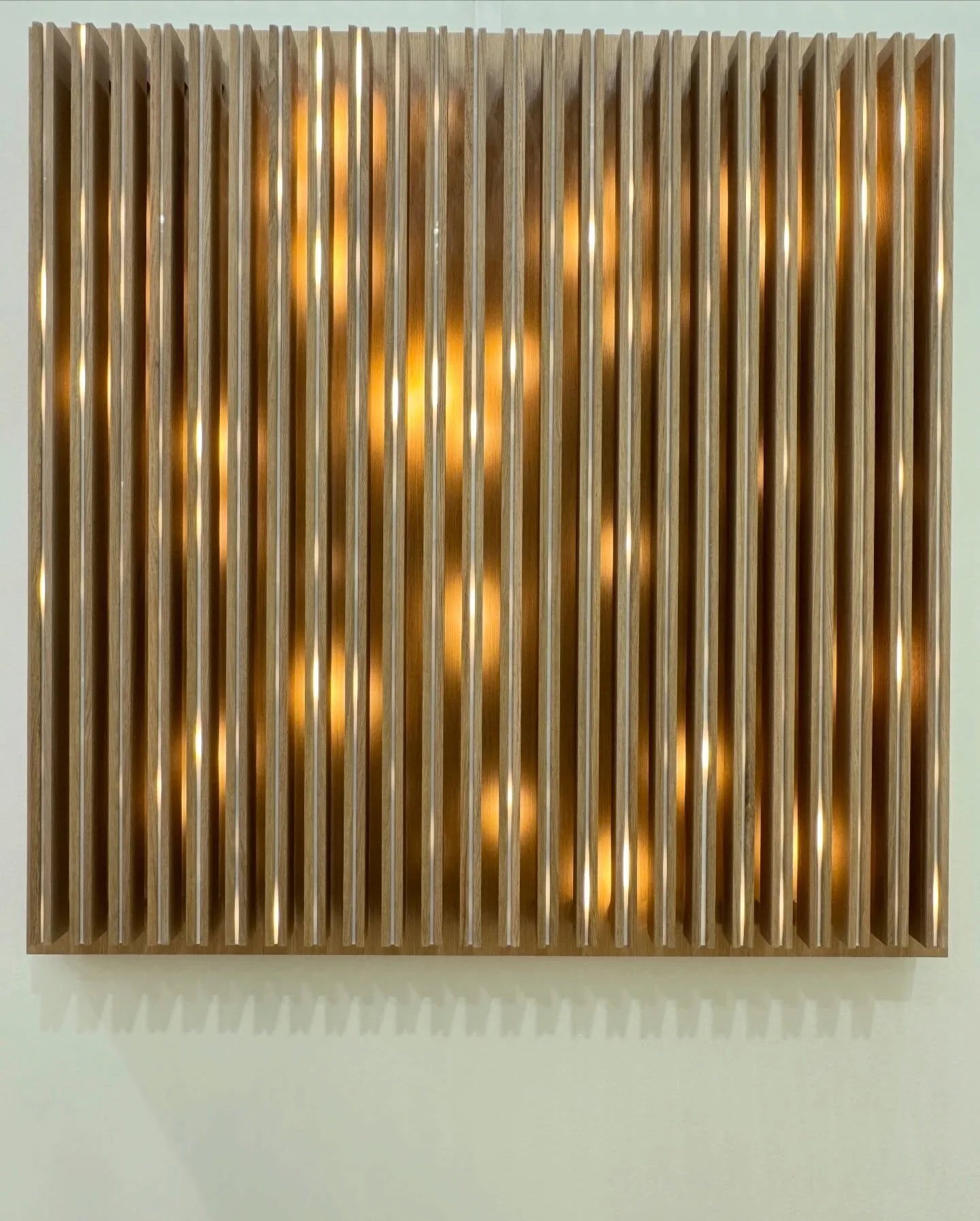 Gold-toned relief artwork with vertical rippling ridges