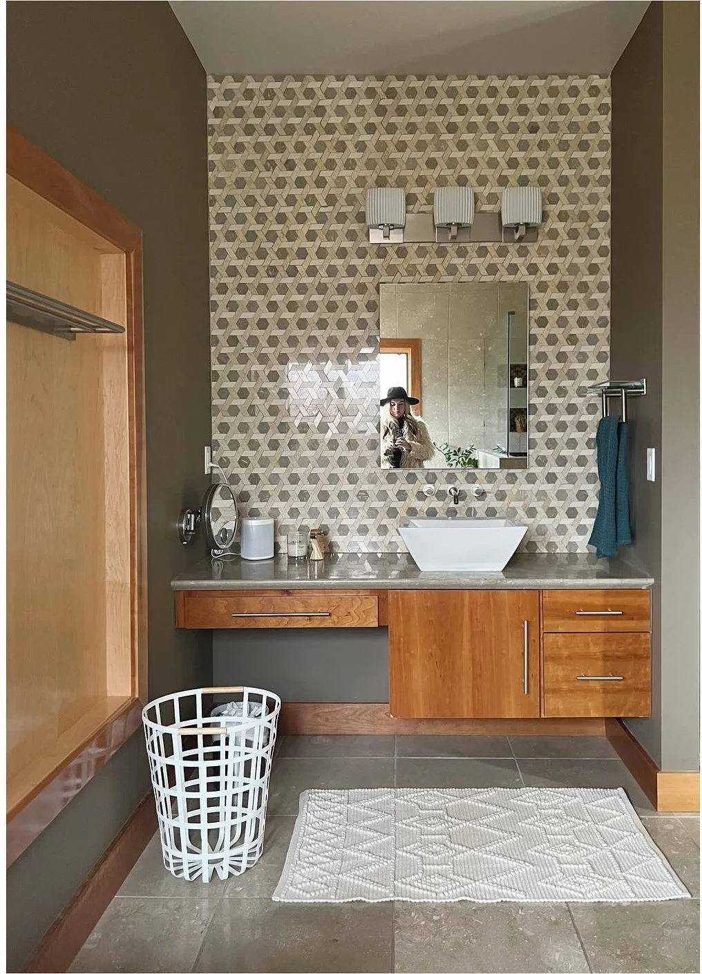 Original wood bathroom vanity beneath small patterned wall tiles