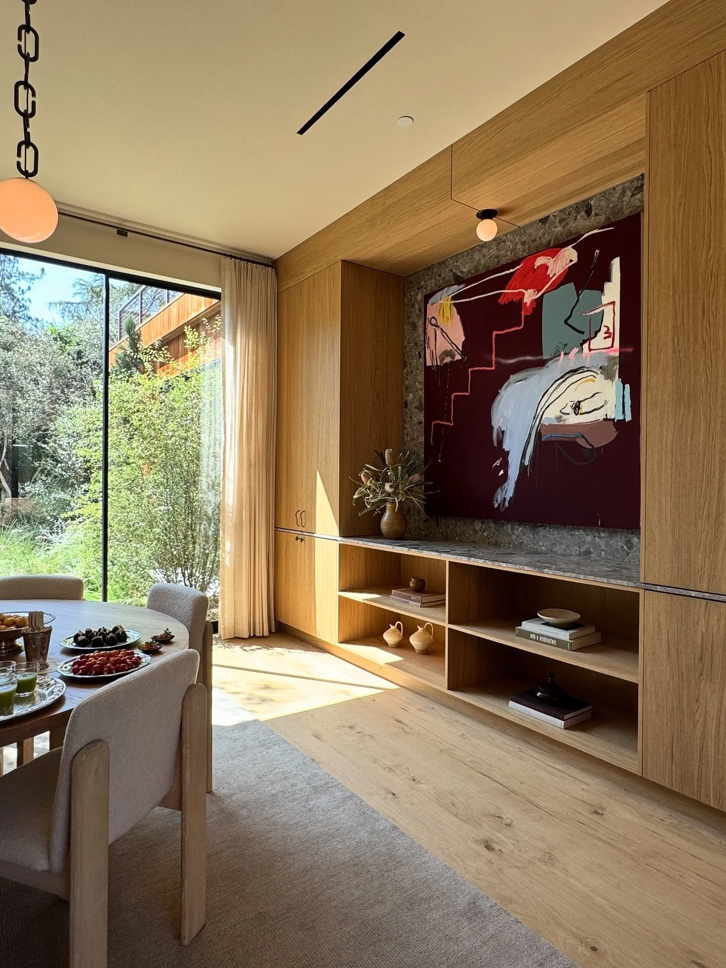 Large colorful artwork set into a wood-paneled dining wall