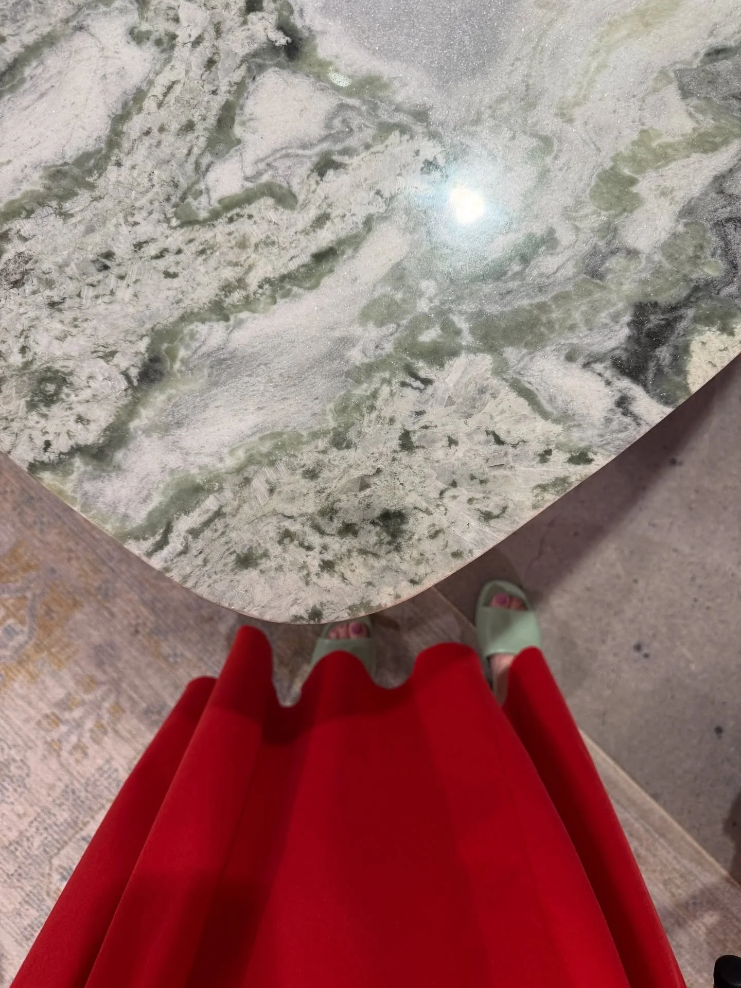 Round pale stone tabletop above a bright red sculptural base