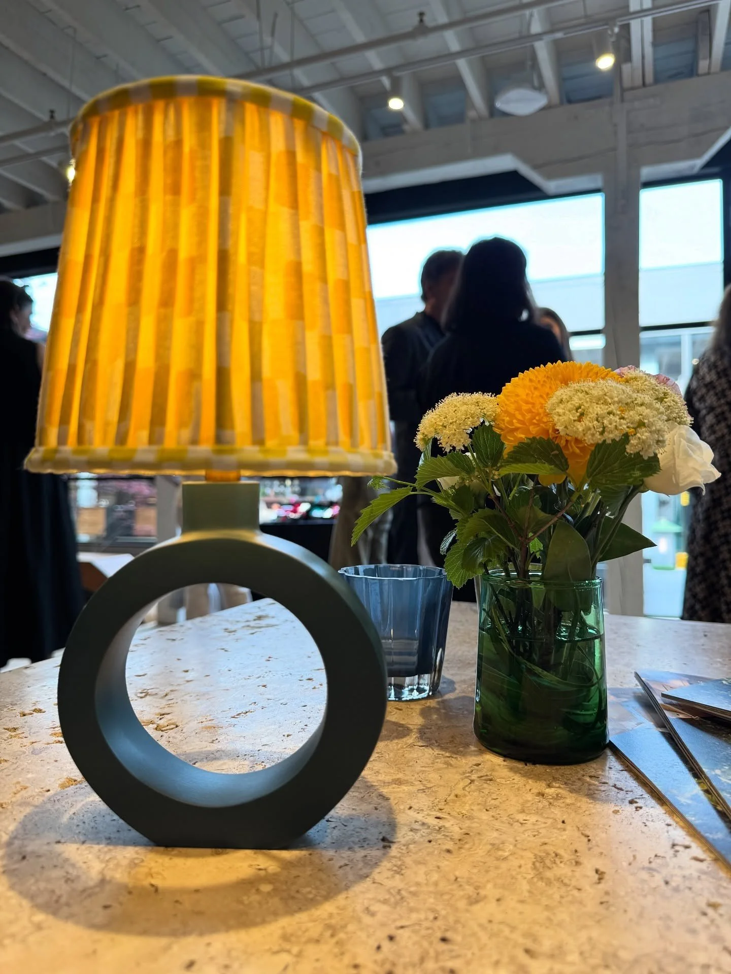 Close view of a round table lamp with a yellow pleated shade