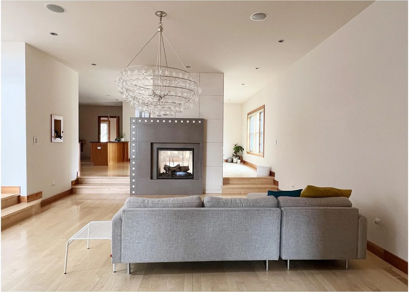 Original living room with gray seating and a dark tiled fireplace