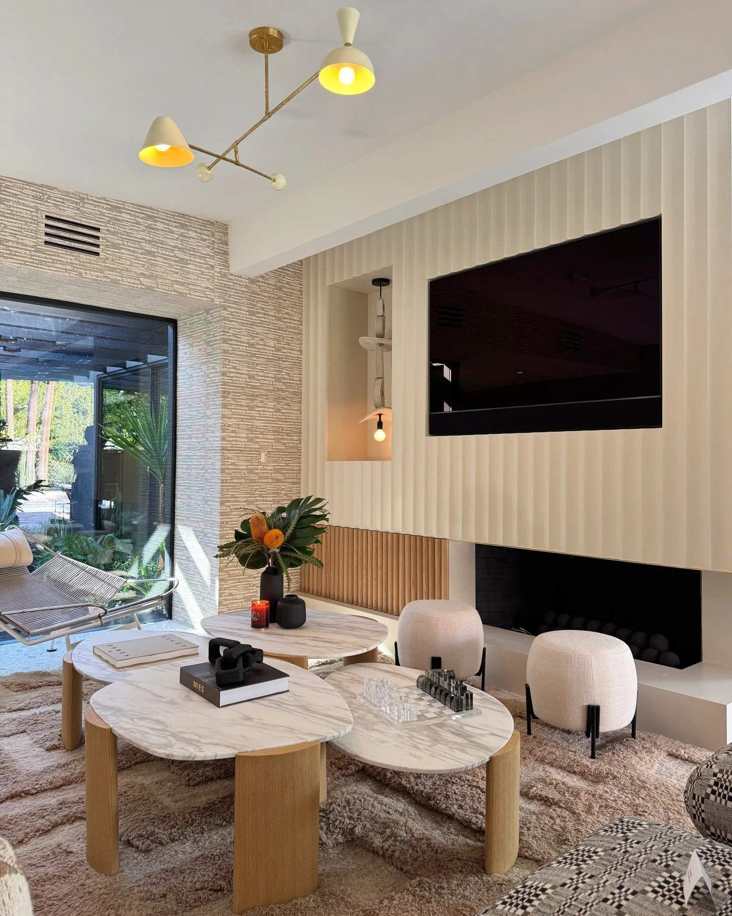 Living room with pale chairs beside a media wall