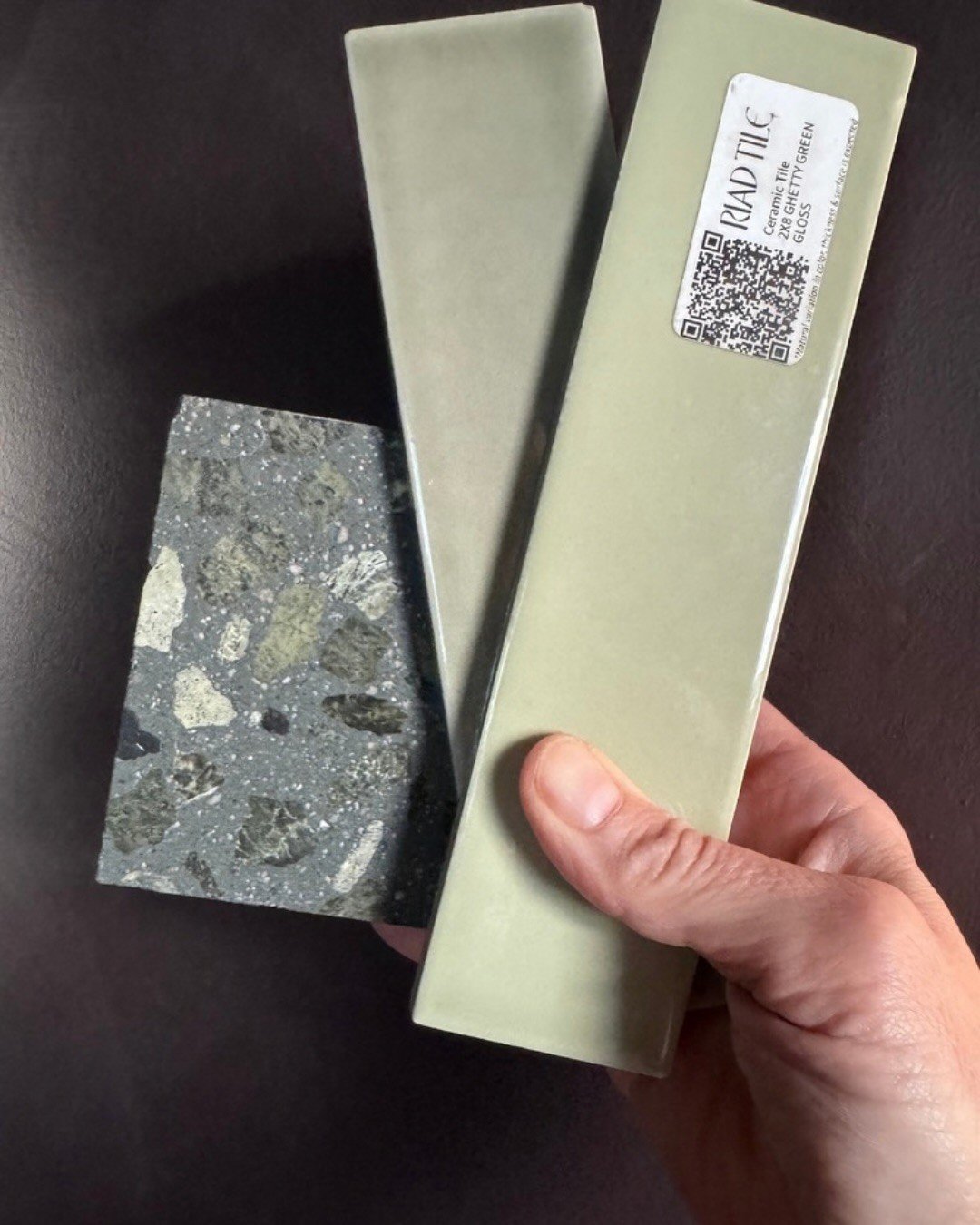 Green tile and terrazzo samples held together for comparison