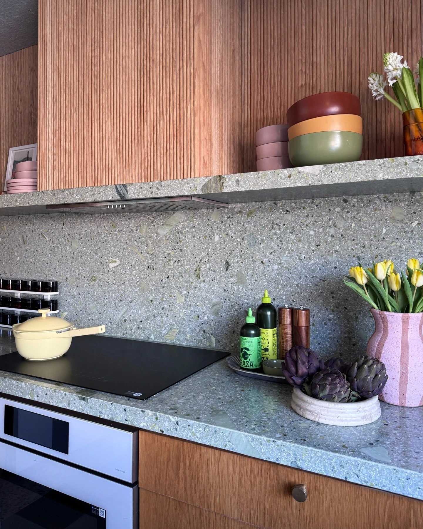 Wood kitchen cabinets with gray terrazzo worktops and shelves