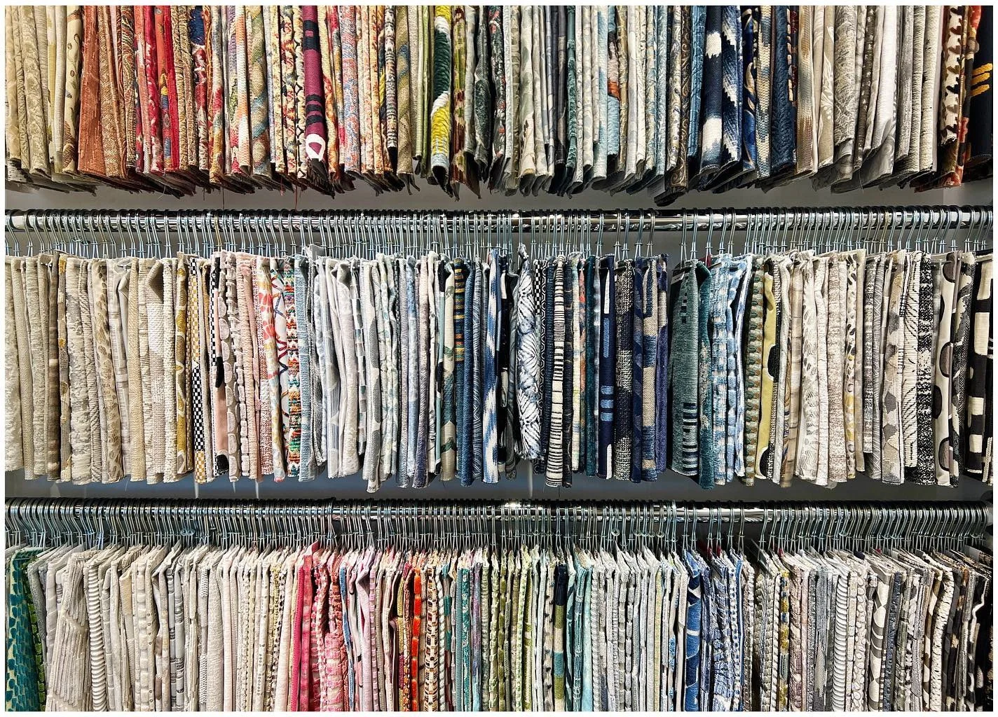 Dense rows of patterned and solid fabric samples arranged on display