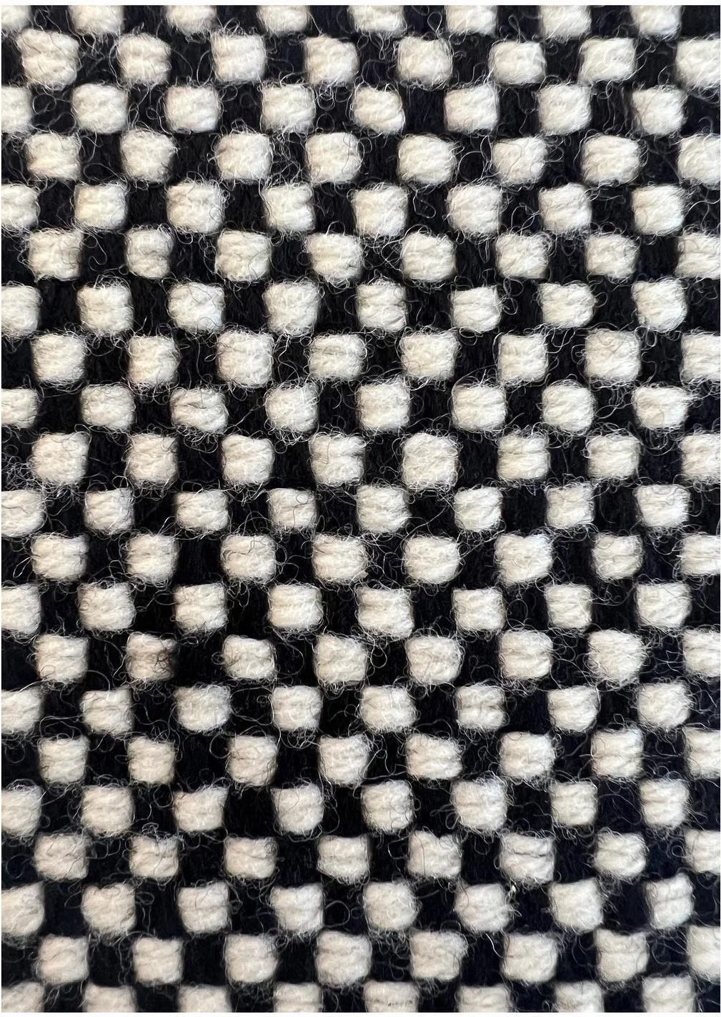 Close view of a black-and-white checked woven textile sample